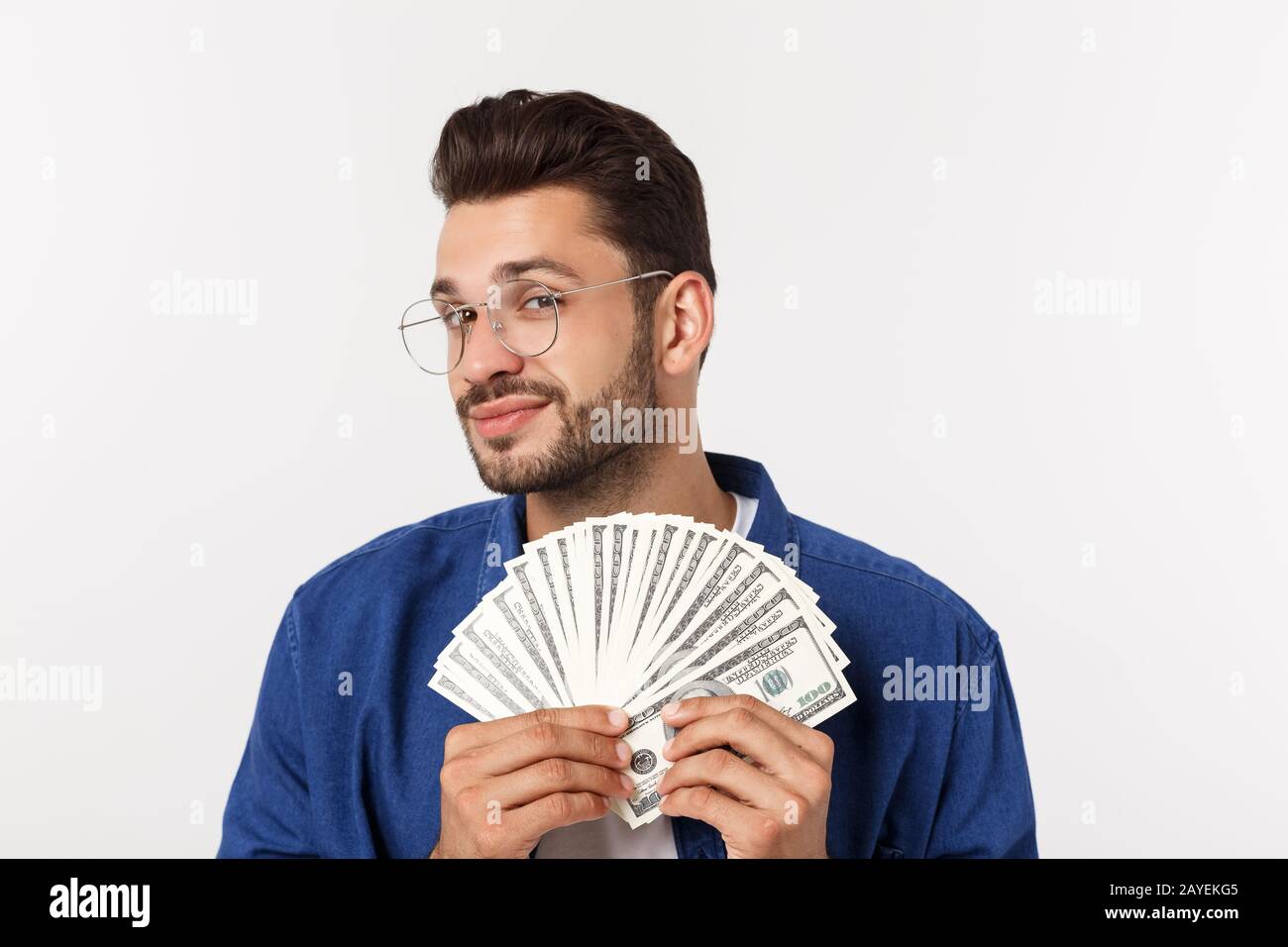 Attraktiver Mann hält bares Geld in der Hand, auf dem isolierten weißen Hintergrund Stockfoto