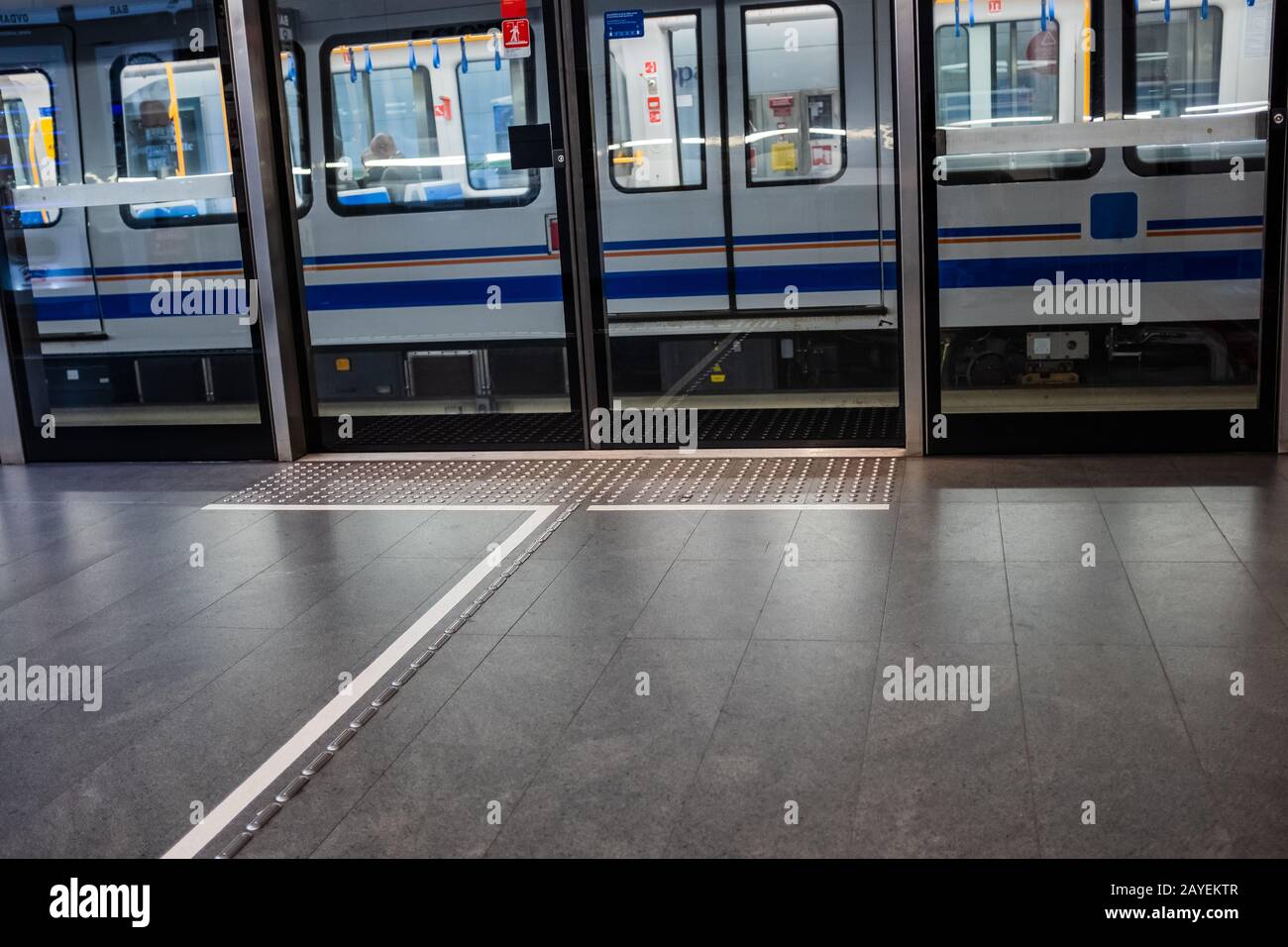 Ein Zug, der vom Bahnhof Europa mit der Brescia Metro (Italien) abfährt. Die Plattform ist mit Bildschirmtüren und taktiler Bodenfläche ausgestattet. Stockfoto
