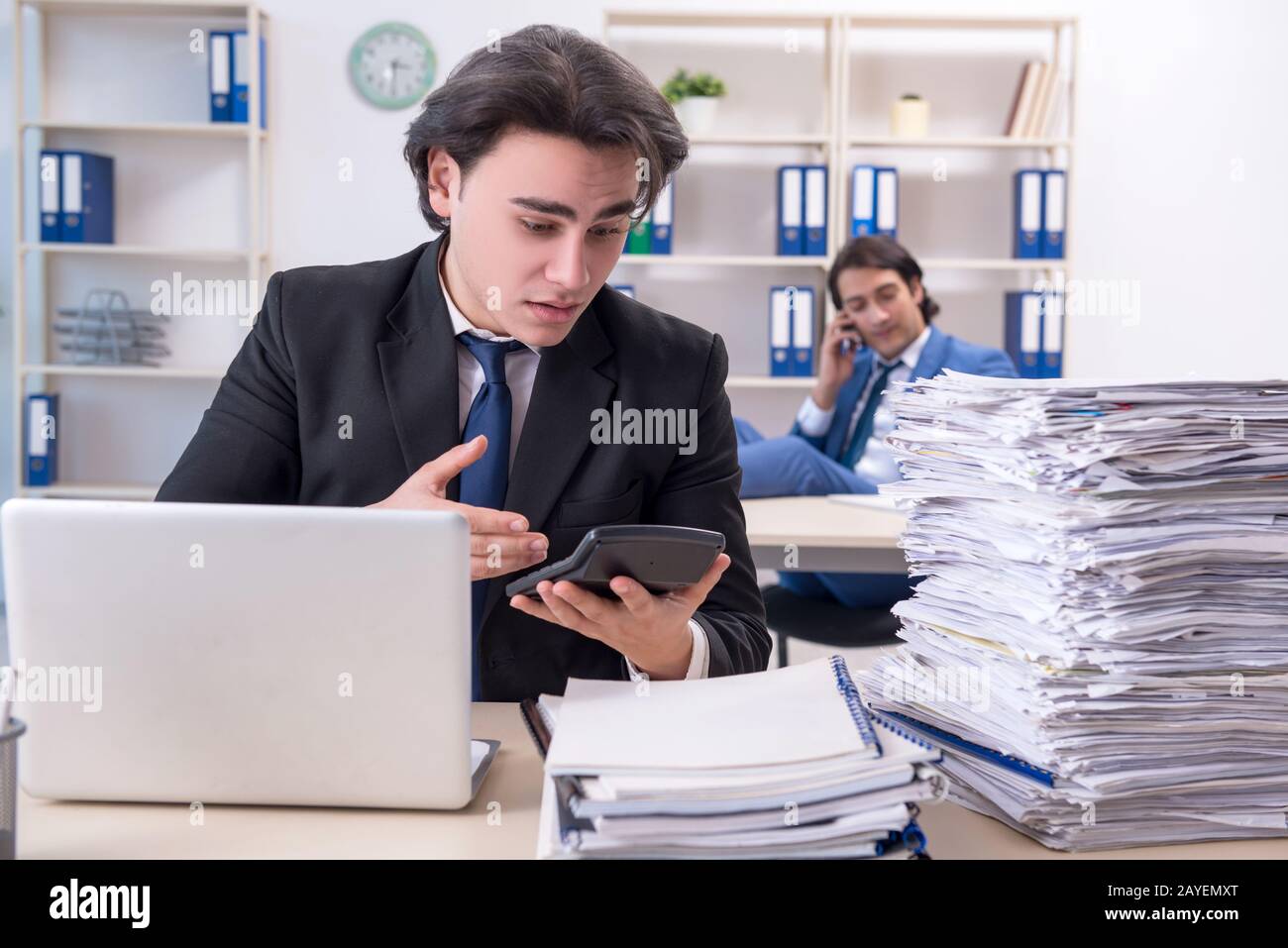 Zwei männliche Kollegen mit übermäßiger Arbeit unzufrieden Stockfoto