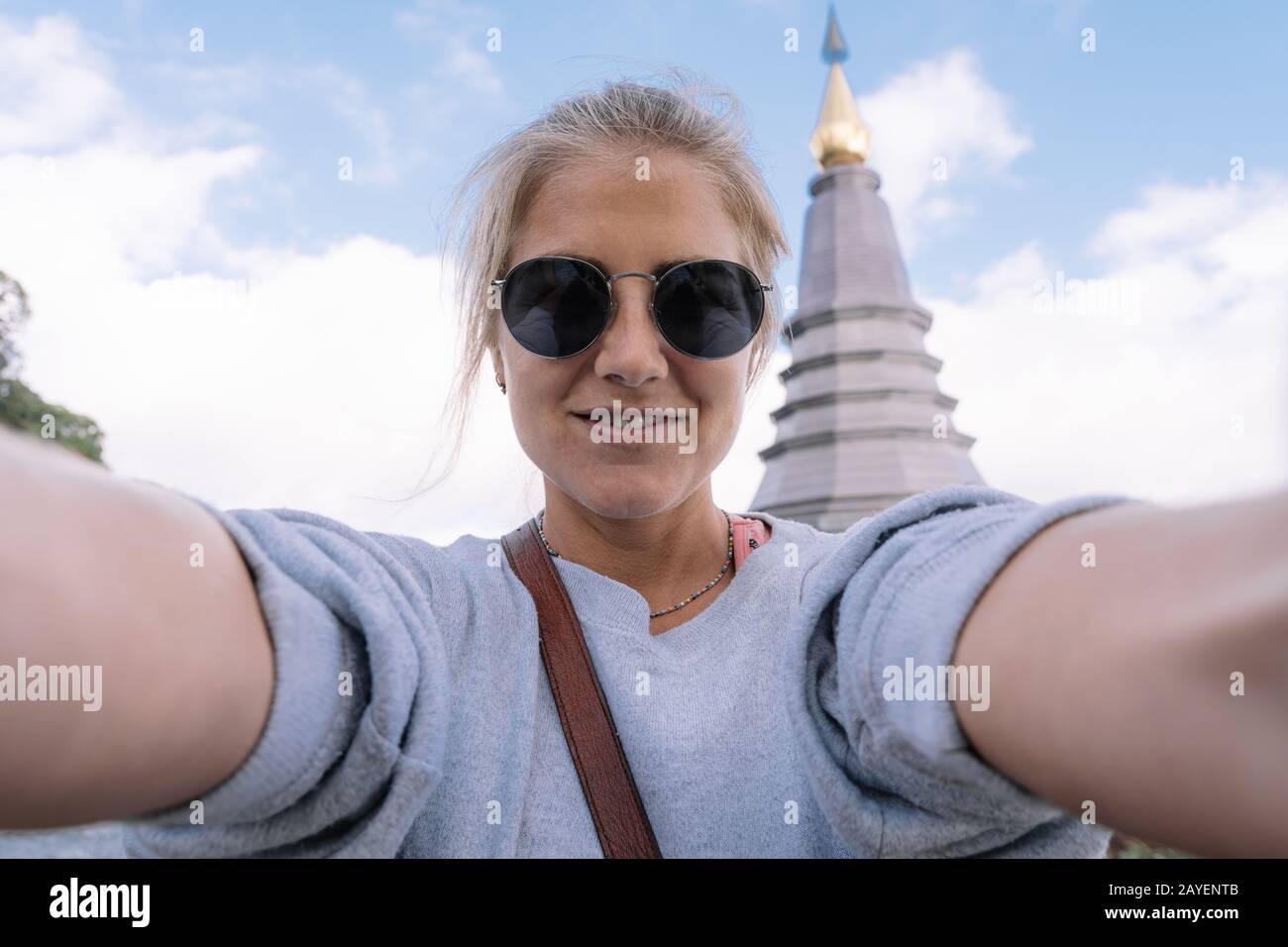 Blondes Mädchen macht selfie mit der Pagode Chiang Mai im Hintergrund in Thailand Stockfoto