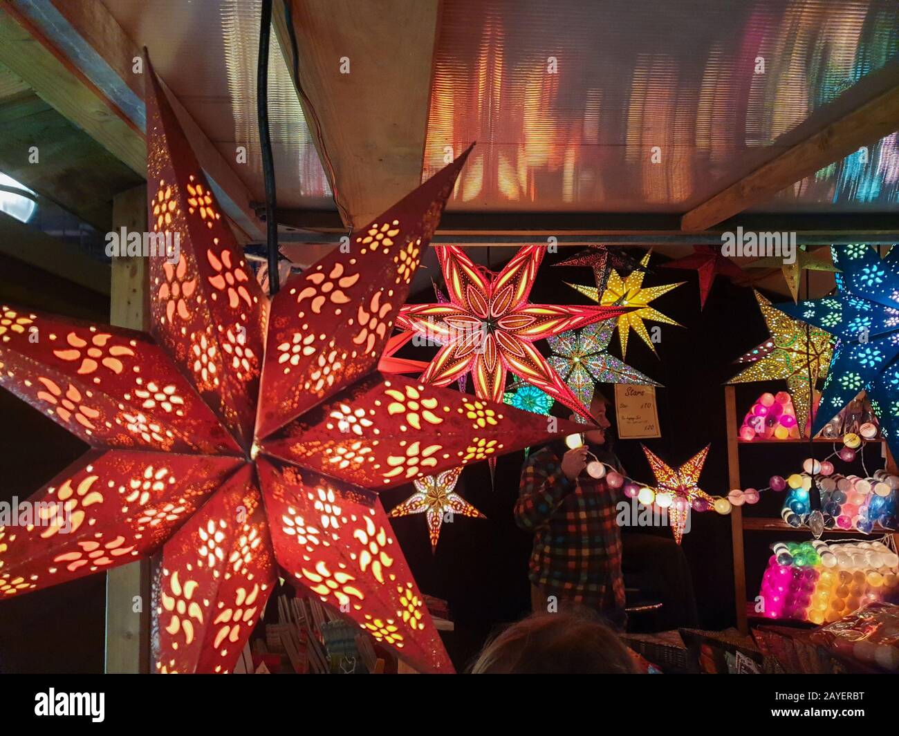 Die sternförmige Papierlampe leuchtet in einem Festplatz auf einem Weihnachtsmarkt in der Nähe des Bahnhofs Liverpool Lime Street Stockfoto