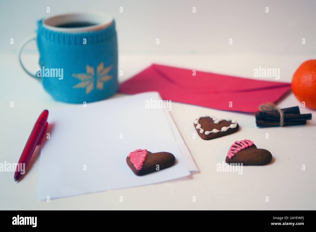 Hearts Lebkuchen Plätzchen mit leerem Buchstaben und Umschlag. Teetasse auf weißem Tisch. Köstliche Hausgemachte Hearts Plätzchen auf weißem Hintergrund. Plätzchen Stockfoto