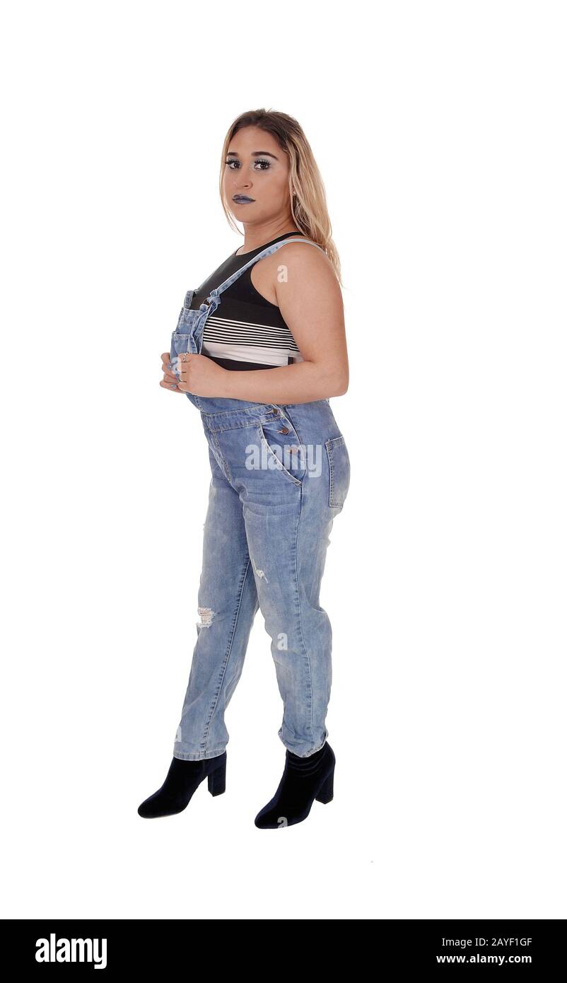 Junge Frau steht in Jeanshosen im Profil Stockfoto