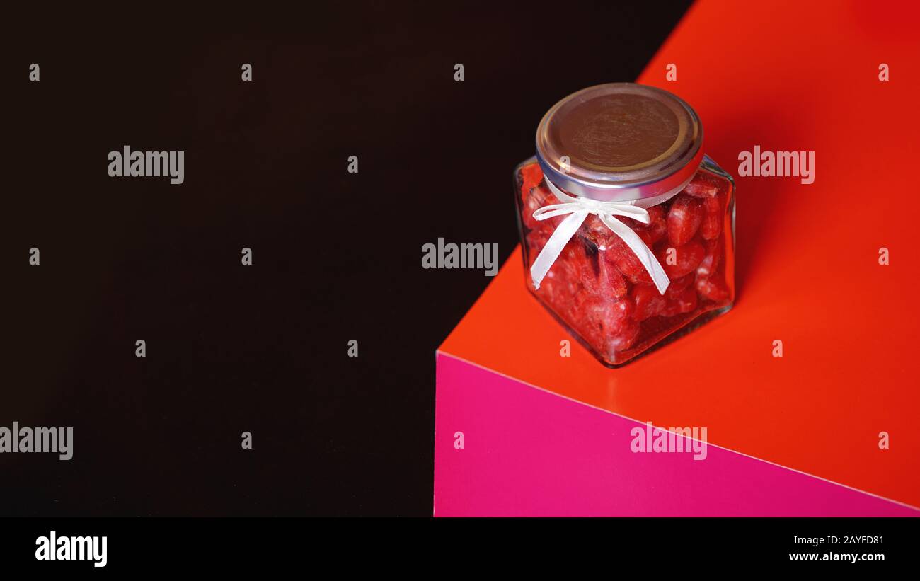 Valentinstag und Liebeskonzept. Herzen im Glas mit rotem und schwarzem Hintergrund Stockfoto