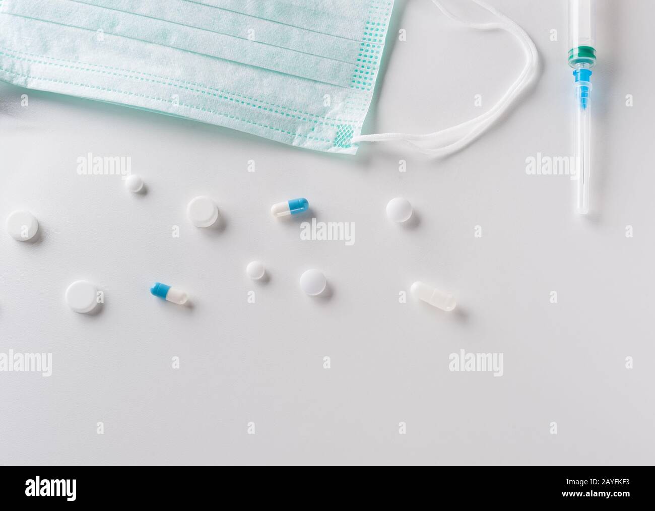 Pharmazeutische Medikamente, Tabletten, chirurgische Schutzmaske und Kunststoffspritze auf hellem Hintergrund. Epidemie- und Virus-Konzept. Horizontal . Stockfoto