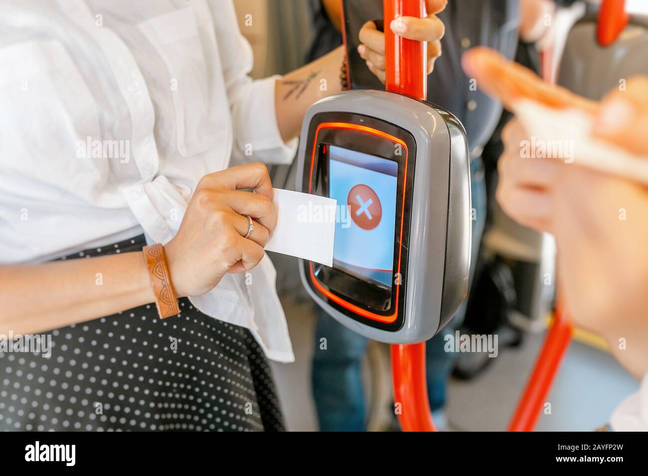 Frau, die versucht, das elektronische Ticket im öffentlichen Verkehr zu validieren und die Maschine verweigert, das Ticket zu lesen Stockfoto