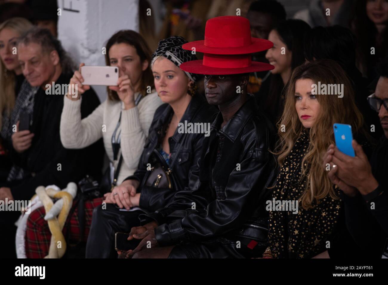 Der Mann hinter dem roten Hut in der ersten Reihe während der Minderjährigen bei Fashion Scout als Teil der London Fashion Week Februar 2020 Show im Victoria House, Bloomsbury, London. Stockfoto