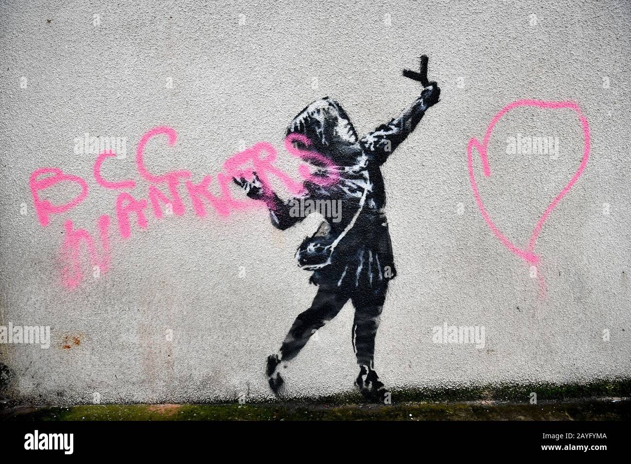 Das NOTIZBILD ENTHÄLT DAS WORT "SCHWÖREN", EIN Banksy Kunstwerk an der Seite eines Hauses an der Marsh Lane, Barton Hill, Bristol, das am Tag des Valentinstages mit rosafarbener Sprühfarbe vandalisiert wurde. Stockfoto