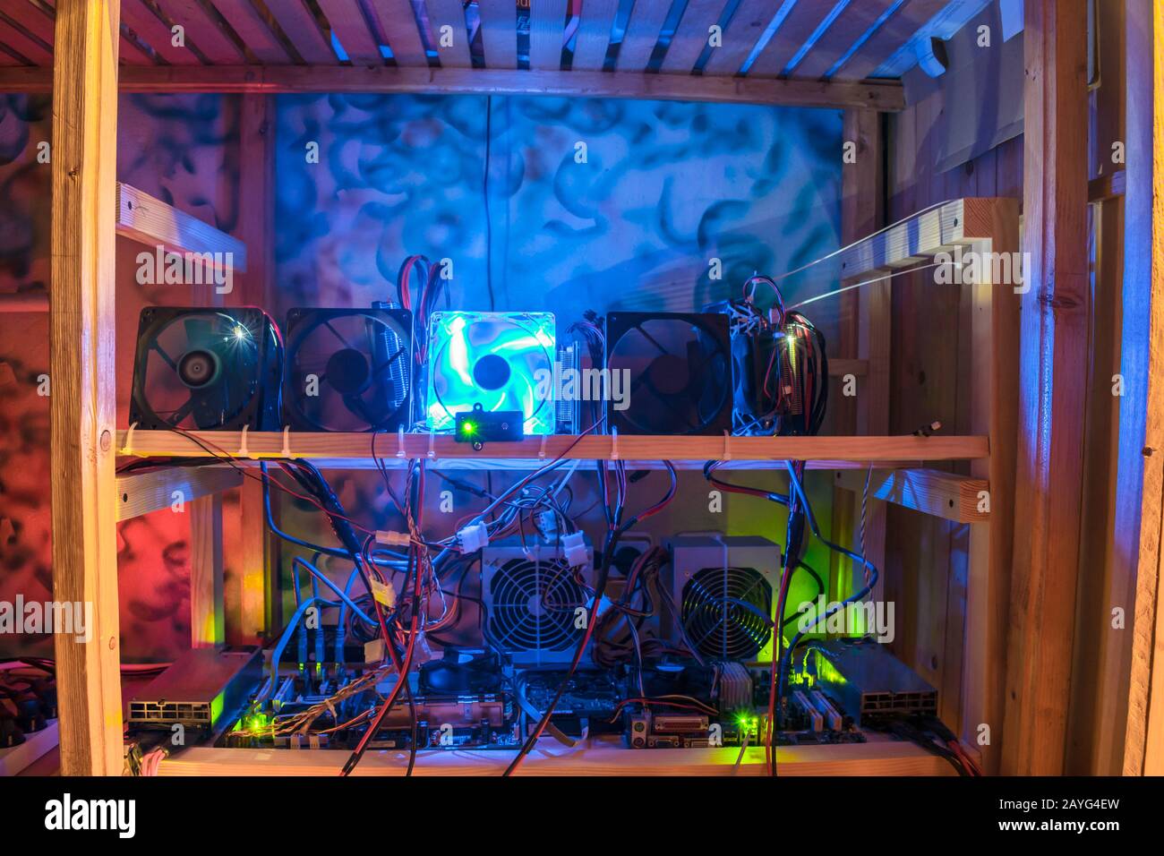 Der Bergbaubetrieb für den Abbau von Kryptowährung befindet sich im Dunkeln auf Holzregalen. Computerausrüstung für die Arbeit mit Bitcoins Stockfoto