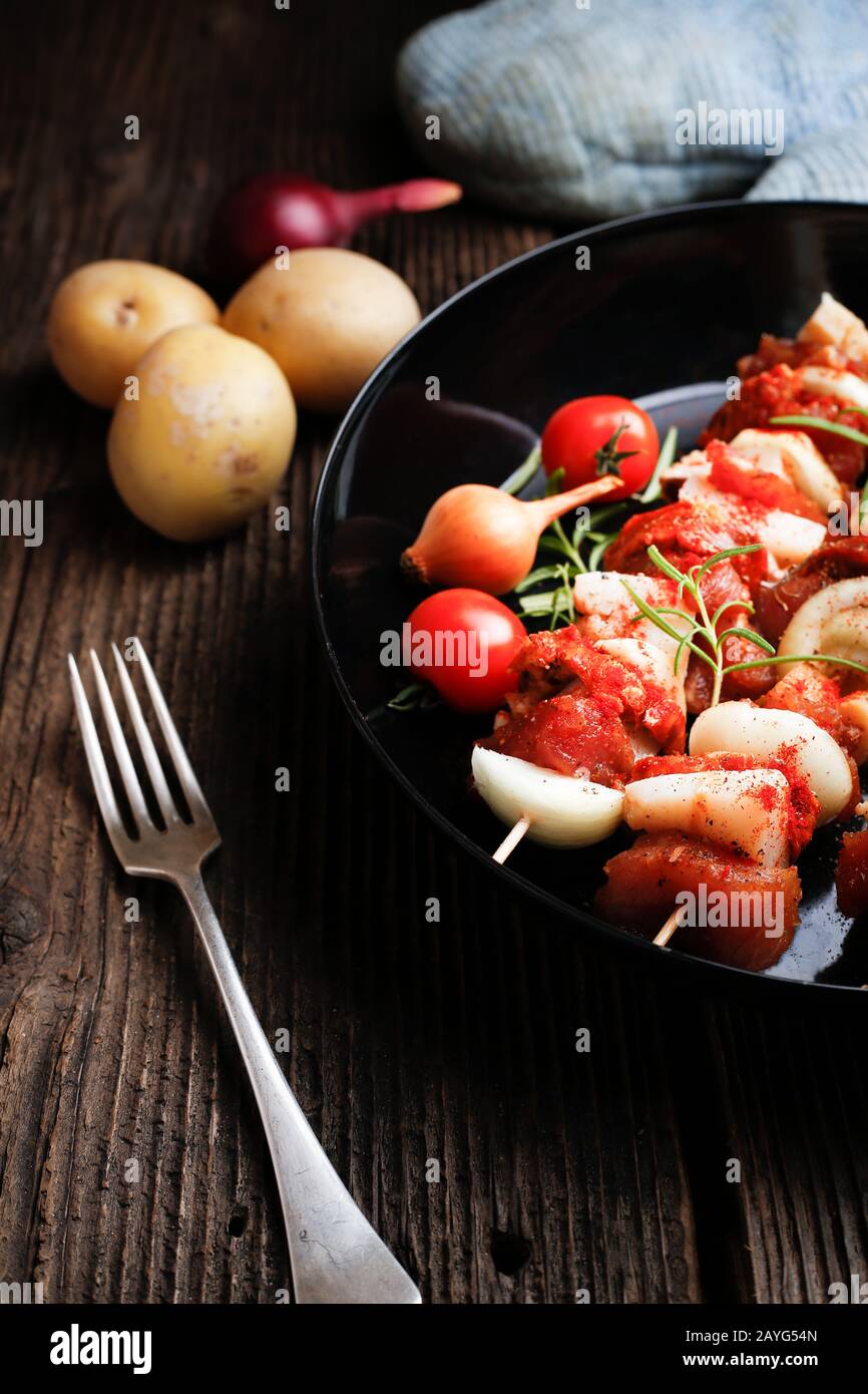 Gemüse und Fleisch auf Holzspießen auf dem Teller. Frittieren Sie das Kebab auf der Bratpfanne. Stockfoto