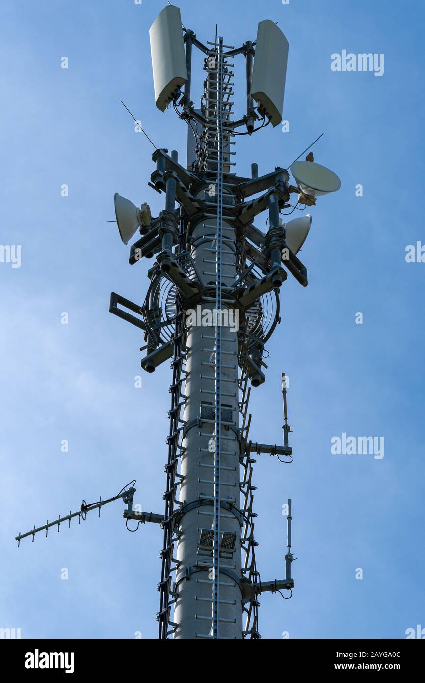 Nahaufnahme von Mobilfunkturm oder Mobilfunkturm mit Antennen und elektronischen Kommunikationsgeräten - Vertikales Format Stockfoto