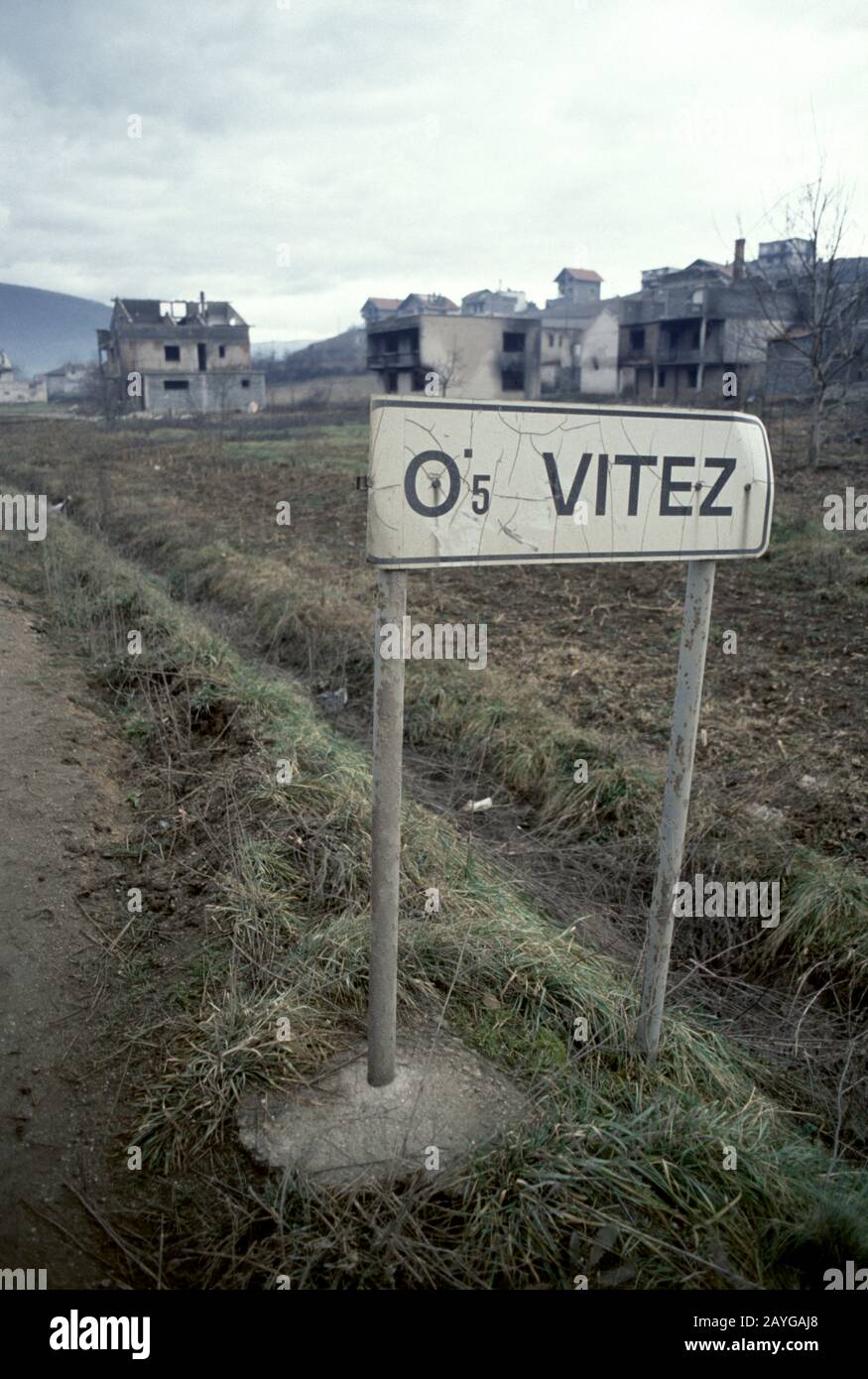 Januar 1994 Ethnische Säuberungen während des Krieges in Zentralbosnien: Verbrannte Häuser und Gebäude bilden eine Kulisse für ein Straßenschild nach Vitez im nördlichen Vorort Grbavica. Stockfoto