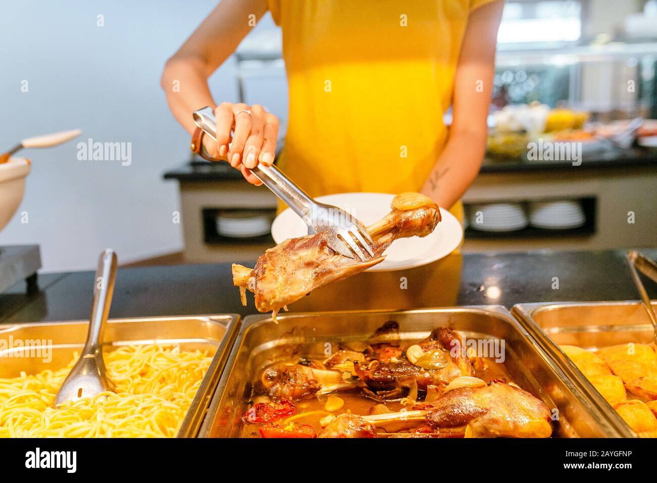 Frau, die verschiedene Snacks und Gerichte am Buffet im Hotelrestaurant auswählt und auswählt. Alles, was Sie essen können Stockfoto