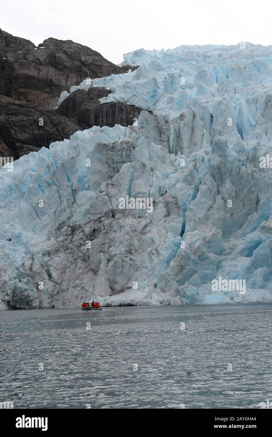 Vor dem Condor-Gletscher im Agostini-Sound, der Cordillera Darwin, in Feuerland im Süden Chiles, macht ein Tierkreis mit Touristen Kreuzfahrten. Stockfoto