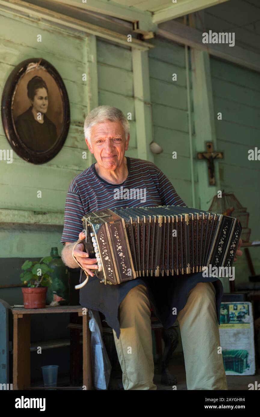 Ein Mann spielt ein Akkordeon in La Boca, einem Stadtviertel von Buenos Aires, das eine große Touristenattraktion in Buenos Aires, Argentinien, ist. Stockfoto