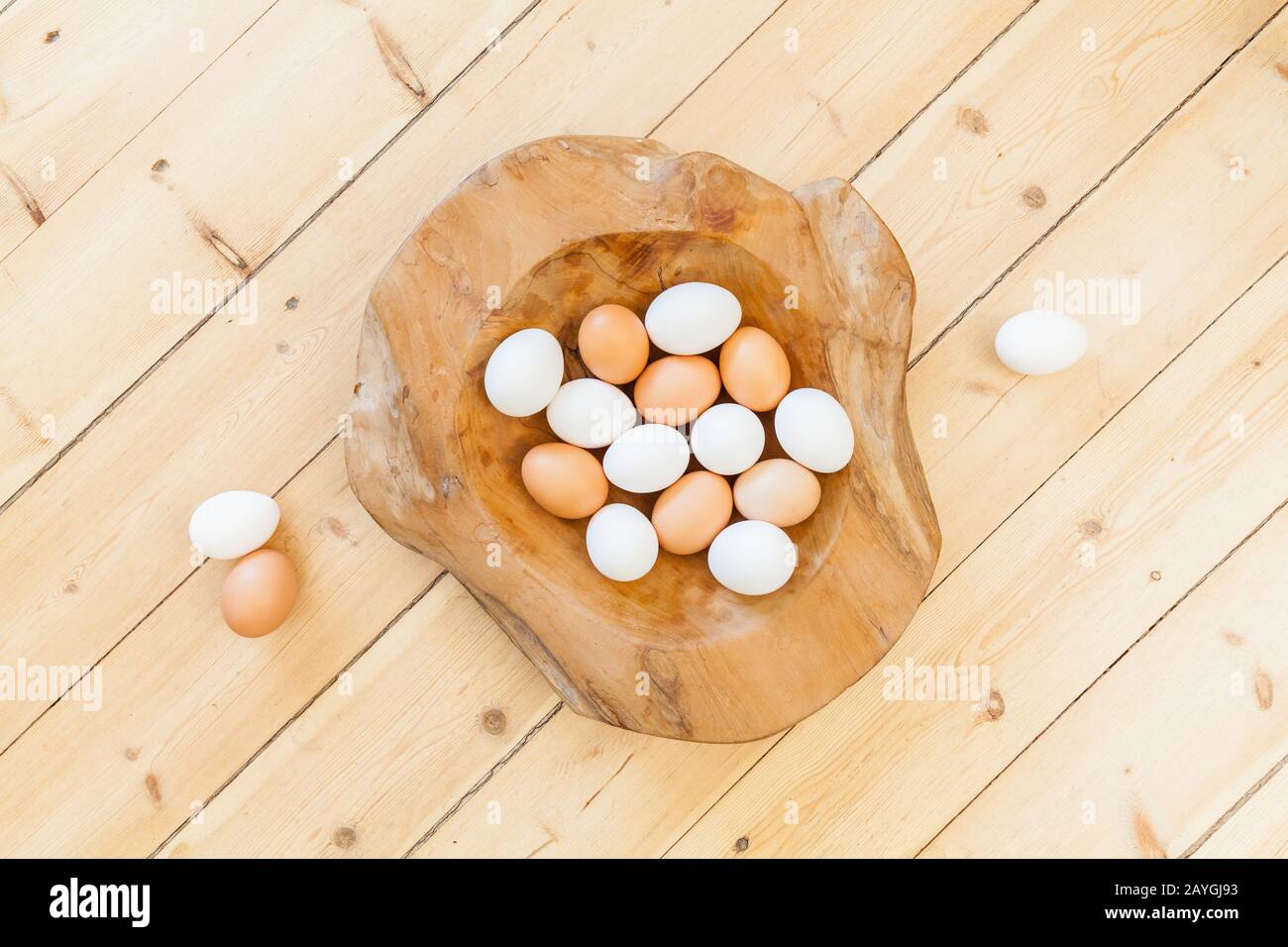 Osterdekoration im Hintergrund mit Eiern in Holzschale auf Holzboden. Federschmuck. Natürliche Gestaltung eines nachhaltigen, gesunden osterlebens Stockfoto