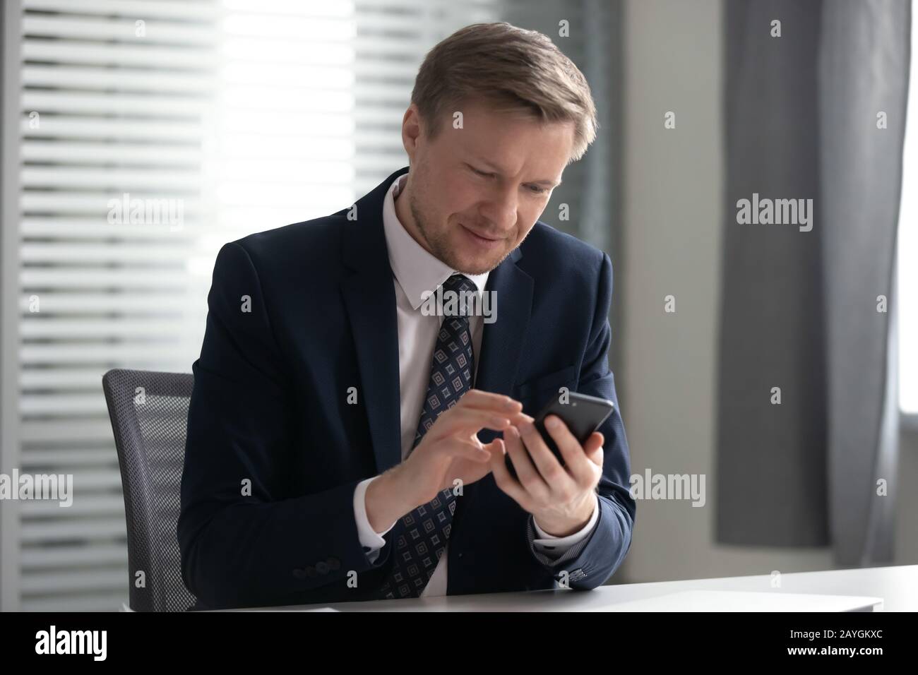 Konzentrierter CEO für Männer, der per Handy SMS oder Messaging telefoniert Stockfoto