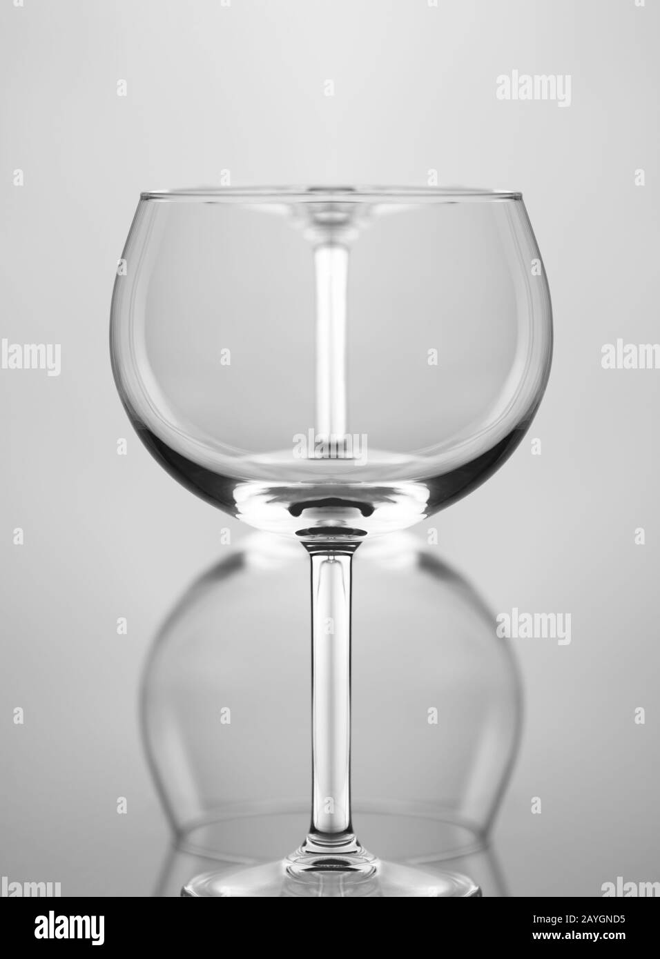 Weinglas abstrakt: Zwei Weingläser eine vor der anderen und auf dem Kopf, vor grauem Hintergrund. Stockfoto