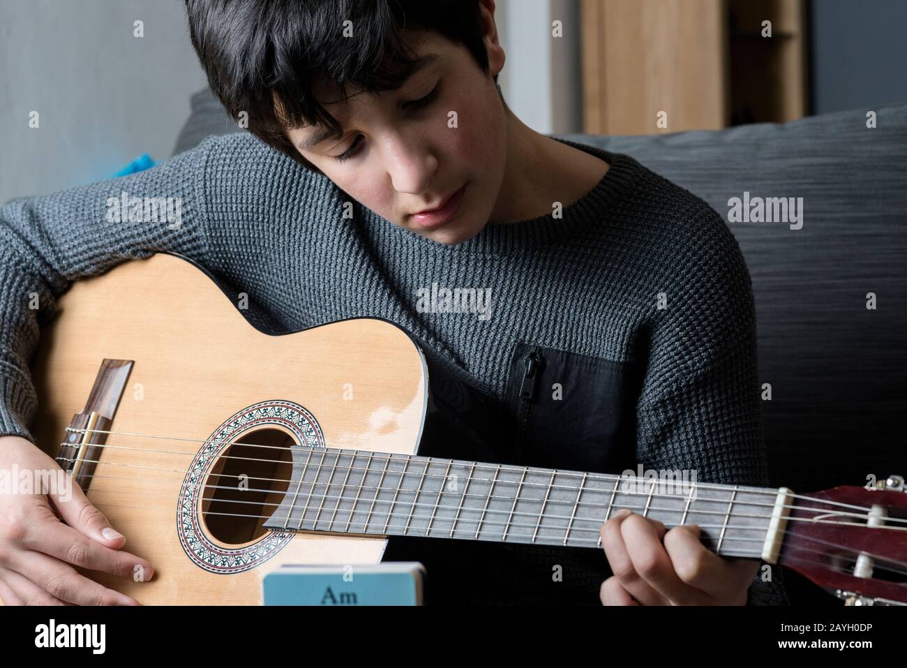 Musikunterricht - Junge, die lernen, dass sie akustische Gitarre spielen Stockfoto