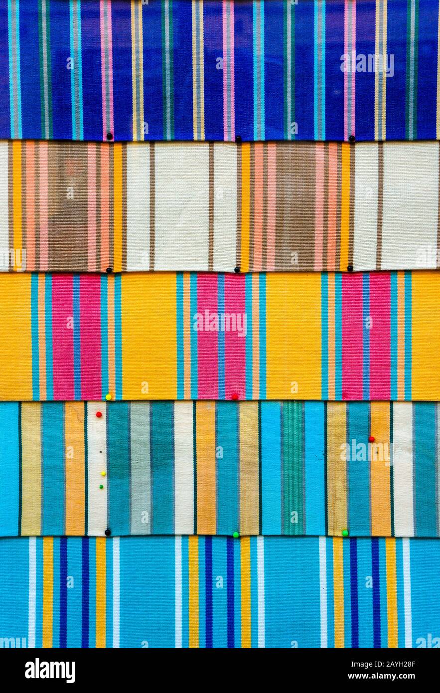 Abstrakte und lebendige Kulisse aus farbenfrohem Material. Stoff mit Pinnwand in hellen Farben und kulturellen und ethnischen Mustern. Stockfoto