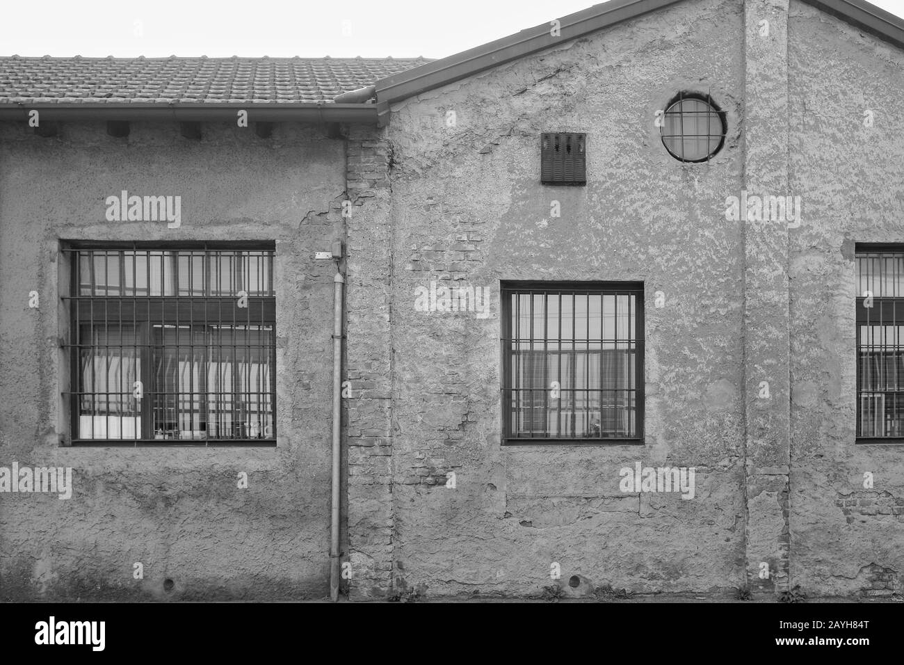 Altmodischer Fabrikschuppen mit runden und quadratischen Fenstern und Zick-Zack-Dach in den südlichen Vorstädten Mailands, Italien Stockfoto