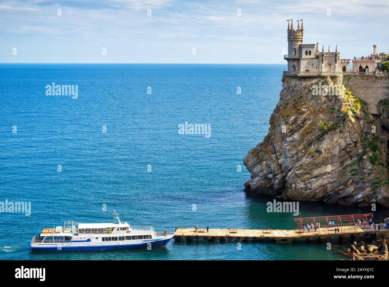 Die malerische Küste des Schwarzen Meeres auf der Krim: Touristenboot am Pier und Swallow's Nest-Burg auf dem Felsen Stockfoto