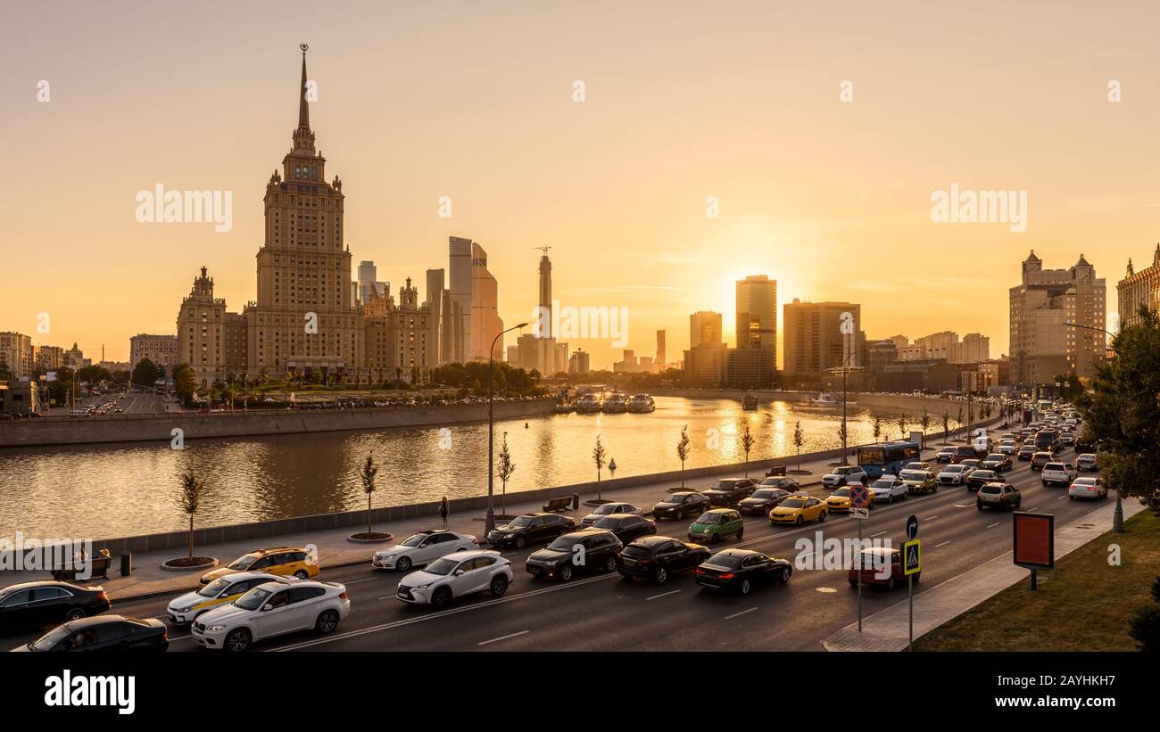 Moskauer Stadtbild bei Sonnenuntergang, Russland. Sonniger Blick auf Moskaus Böschung und Straßenverkehr. Blick auf die Stadt mit dem Moskva-Fluss in Sonnenschein. Urbane Länder Stockfoto