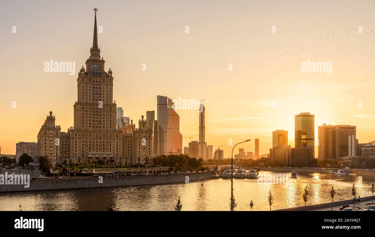 Moskauer Stadtbild bei Sonnenuntergang, Russland. Landschaftlich schöner Blick auf die Stadt mit Radisson Hotel (Ukraine) am Moskva Fluss in Sonnenschein. Dieses alte hohe Gebäude ist Stockfoto