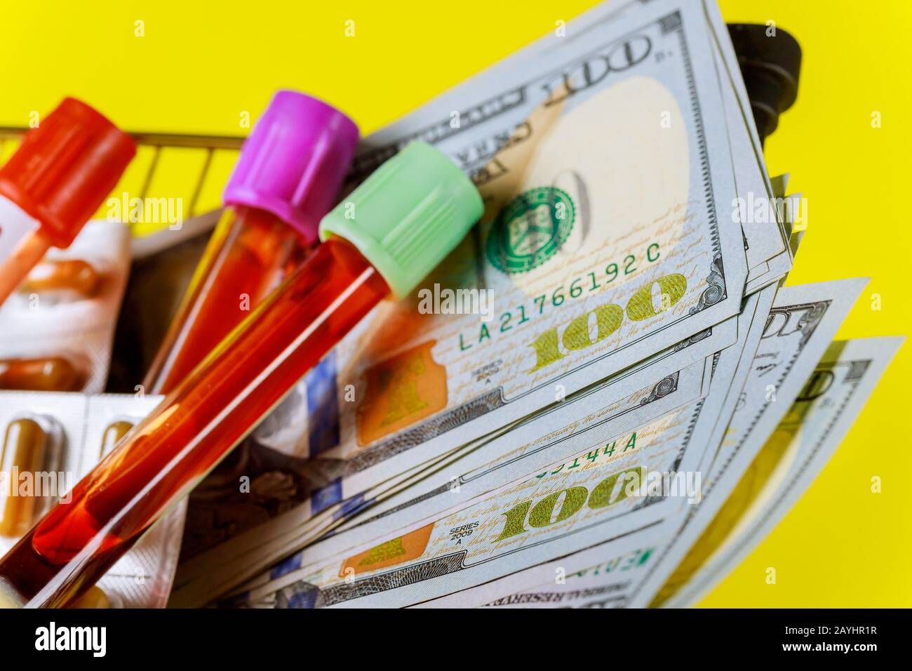 Schließen Sie 100 US-Dollar Rechnungen mit Lebensmittelwagen über Medikamente in Glasröhrchen Blut für Tests Stockfoto