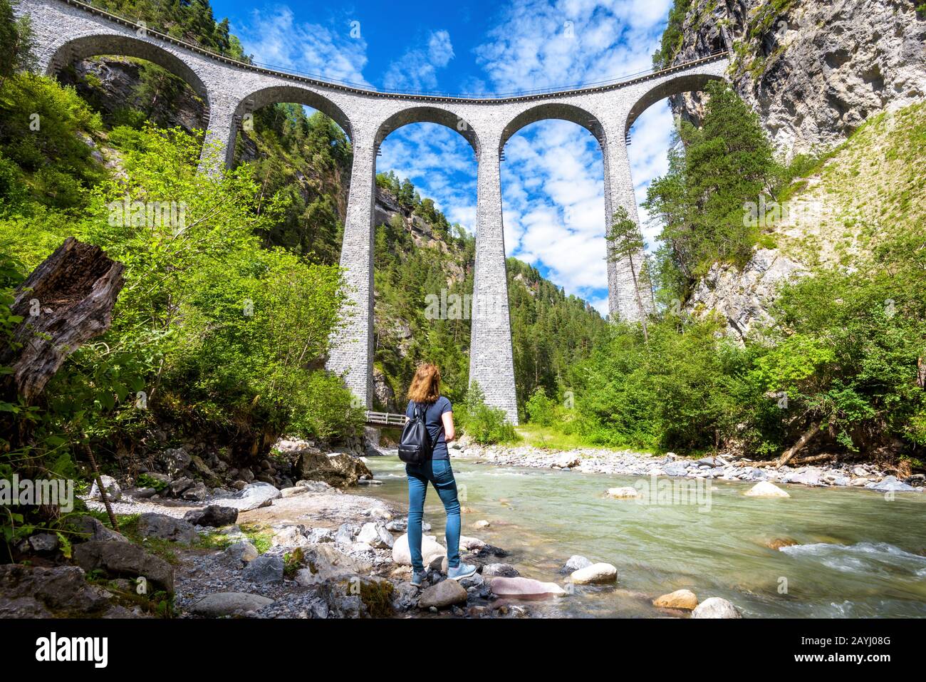 Landwasser-Viadukt in Filisur, Schweiz. Junge Frau schaut auf die berühmte Touristenattraktion. Panorama-Blick auf die hohe Eisenbahnbrücke in den Bergen. A Stockfoto