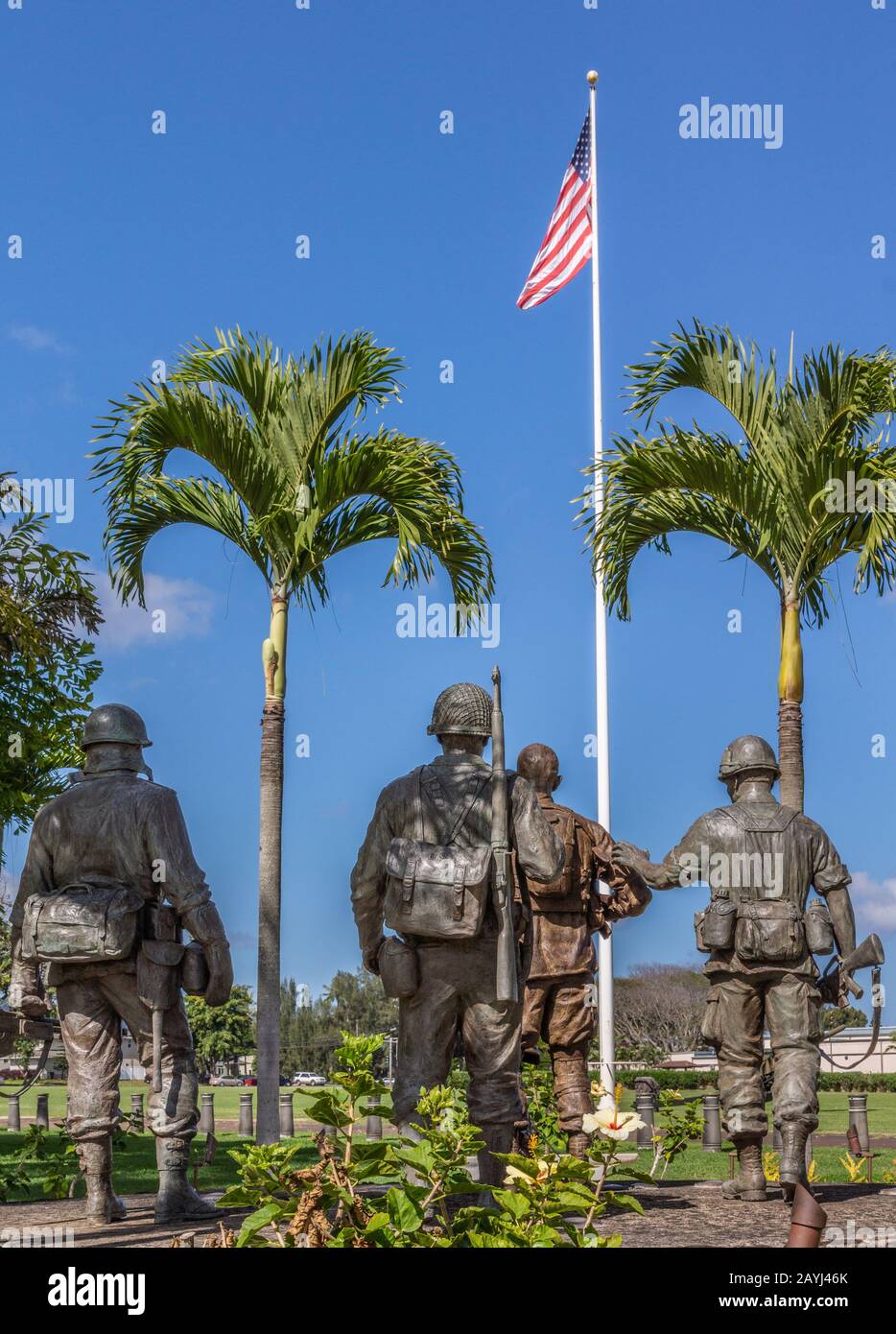 Oahu, Hawaii, USA. - 10. Januar 2012: Statue der Gruppe "United In Sacrifice" von hinten vor der US-Flagge unter blauem Skay in der Schofield Barracks von Ar Stockfoto