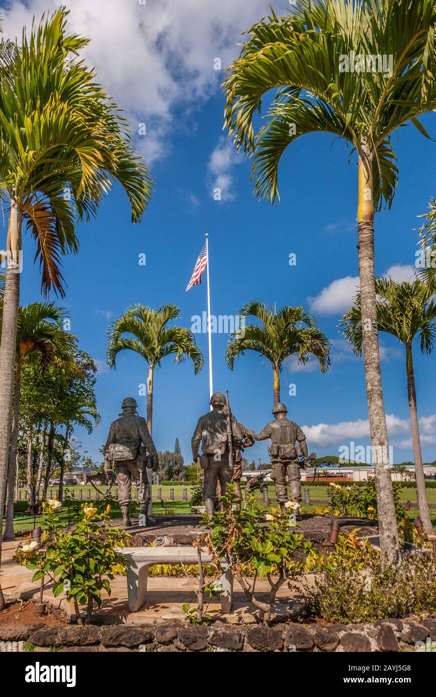 Oahu, Hawaii, USA. - 10. Januar 2012: Statue der Gruppe "United In Sacrifice" von hinten vor der US-Flagge unter blauem Skay in der Schofield Barracks von Ar Stockfoto