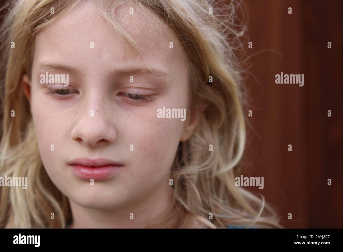 Porträt eines schönen blonden Mädchens mit abgewendeten Augen Stockfoto