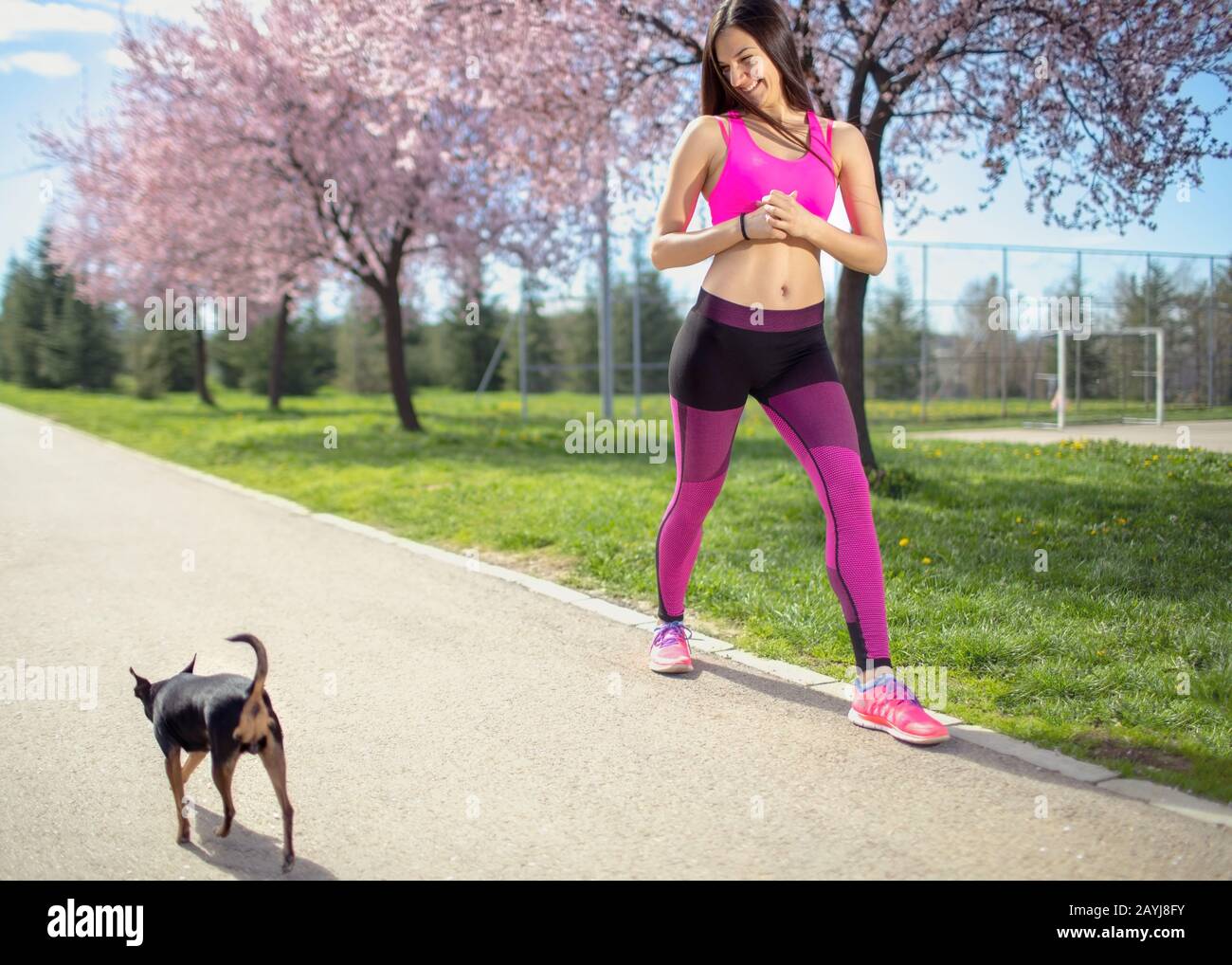 Fitnessfrau und Hund im Park Stockfoto
