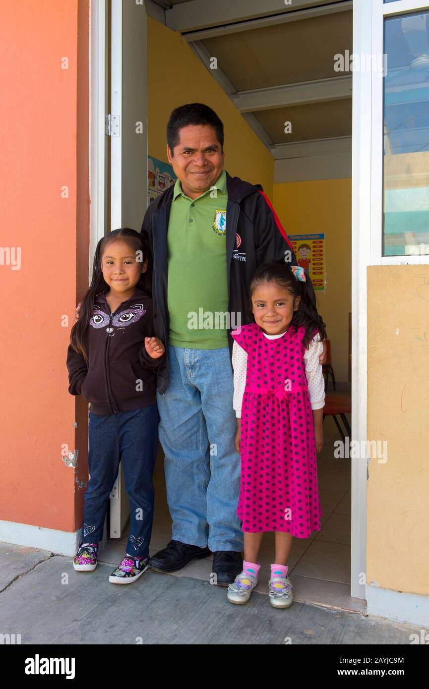 Eine Lehrerin mit zwei Kindergartenmädchen vor dem Klassenzimmer im mixtekischen Dorf San Juan Contreras in der Nähe von Oaxaca, Mexiko. Stockfoto