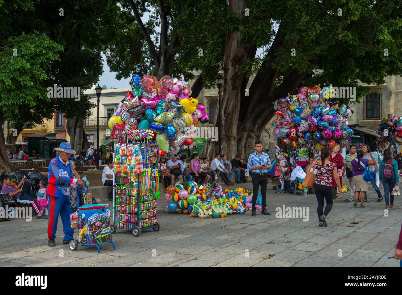 Menschen, die Ballons auf dem Platz vor der Kathedrale Unserer Lieben Frau von Der Himmelfahrt in der Stadt Oaxaca de Juarez, Oaxaca, Mexiko verkaufen. Stockfoto