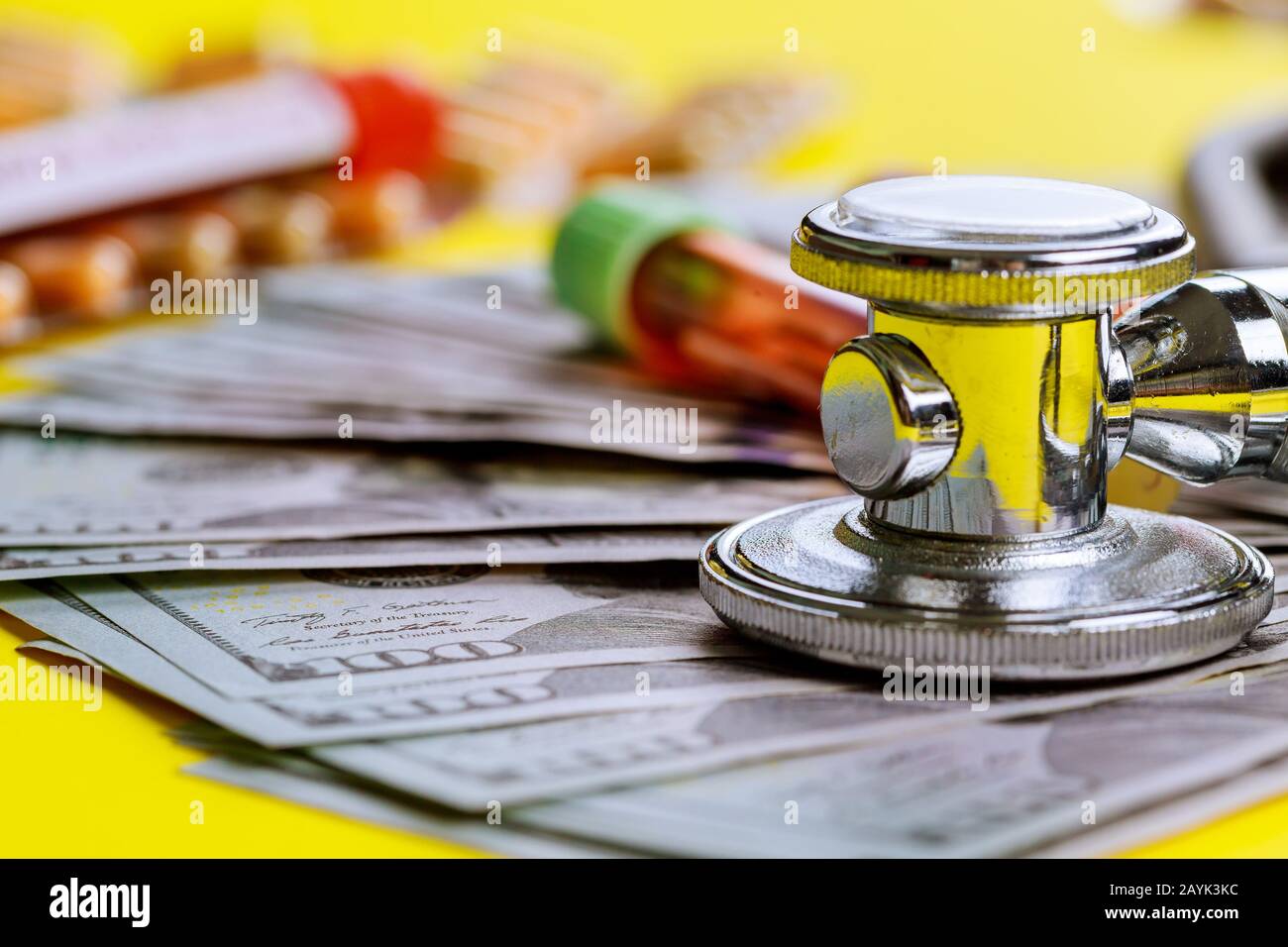 Medizinisches Konzept, Stethoskop auf dem Schreibtisch mit Blick auf Dollar-Banknote auf Reagenzgläsern in teuren Labormedizin Stockfoto