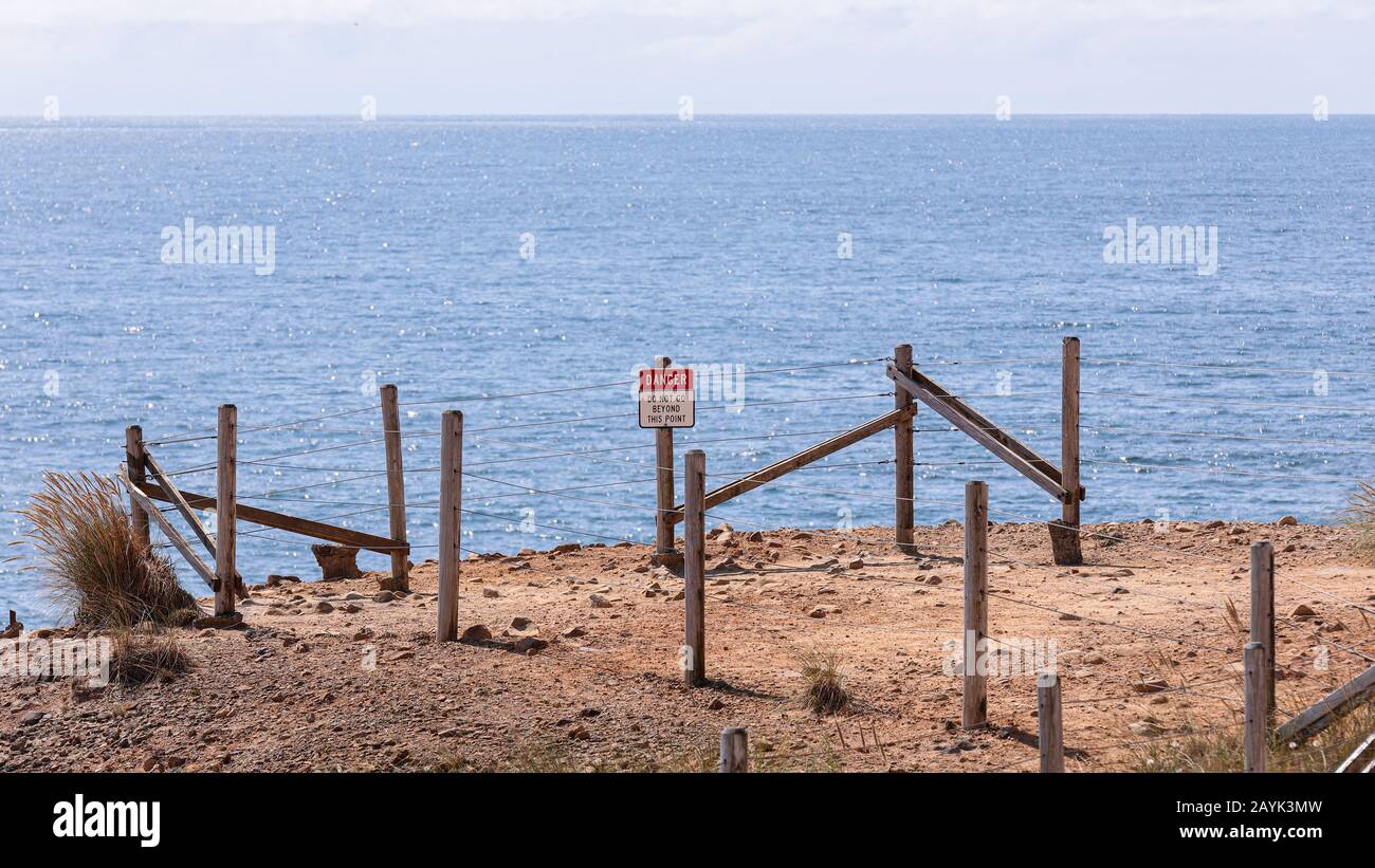 Sing posted on an Edge of a Cliff of Cape Kiwanda read "danger" and "Do not go Beyond this point". Eine Barriere um den Aussichtspunkt. Stockfoto