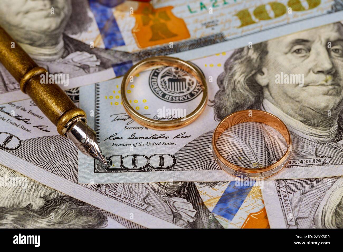 Hochzeit Vertrag der Bequemlichkeit, goldener Hochzeitsring auf Stift auf Dollar-Banknoten Hintergrund Stockfoto