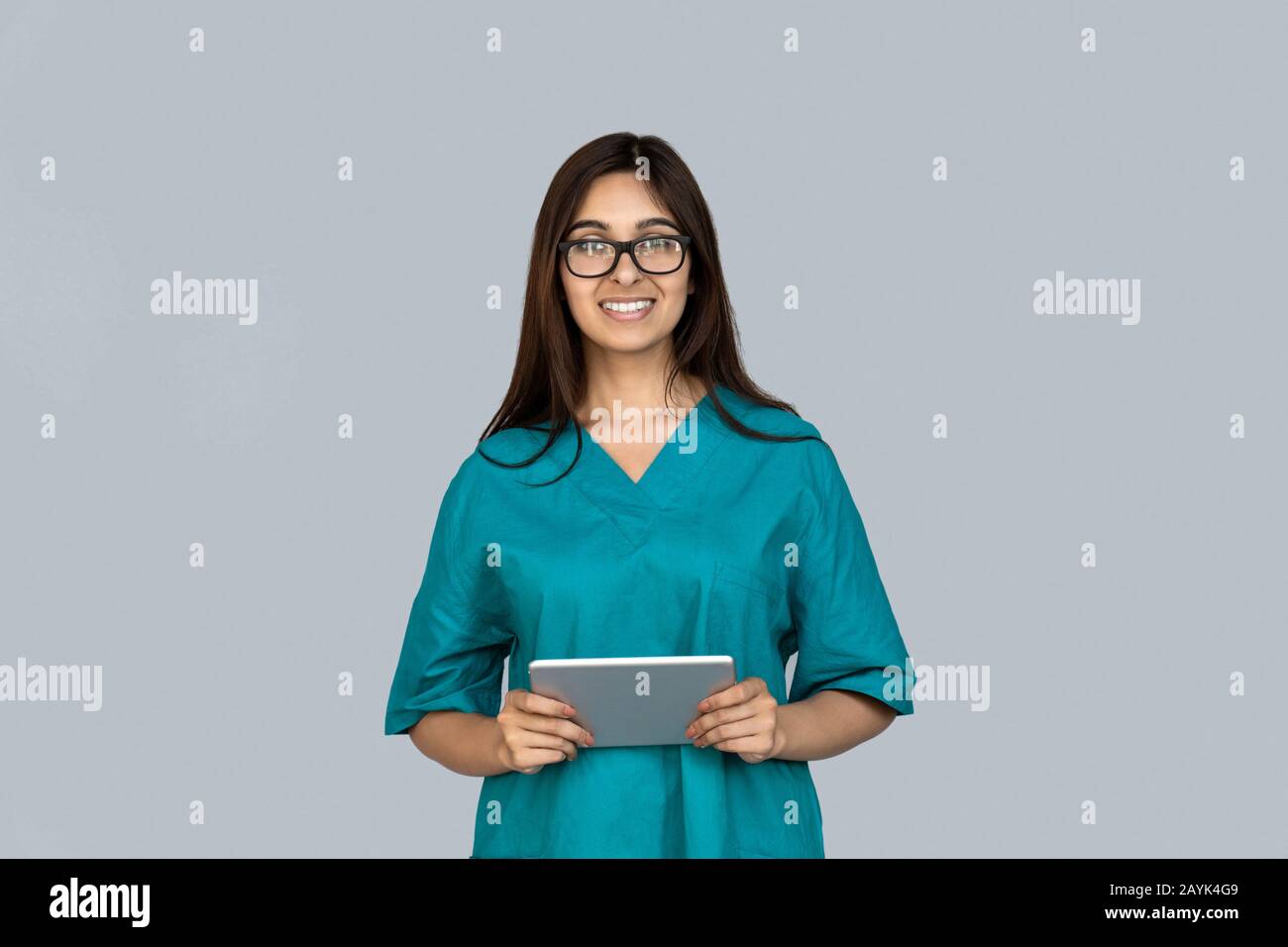Glückliche junge Erwachsene indianerin in einem Arzt, der einen Tablettencomputer hält Stockfoto