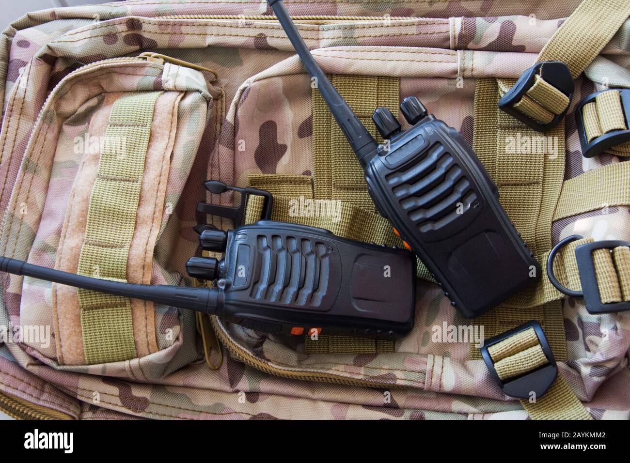 Zwei tragbare Funkgeräte vor dem Hintergrund eines militärischen Rucksacks tarnen modernen Armeeradio Stockfoto