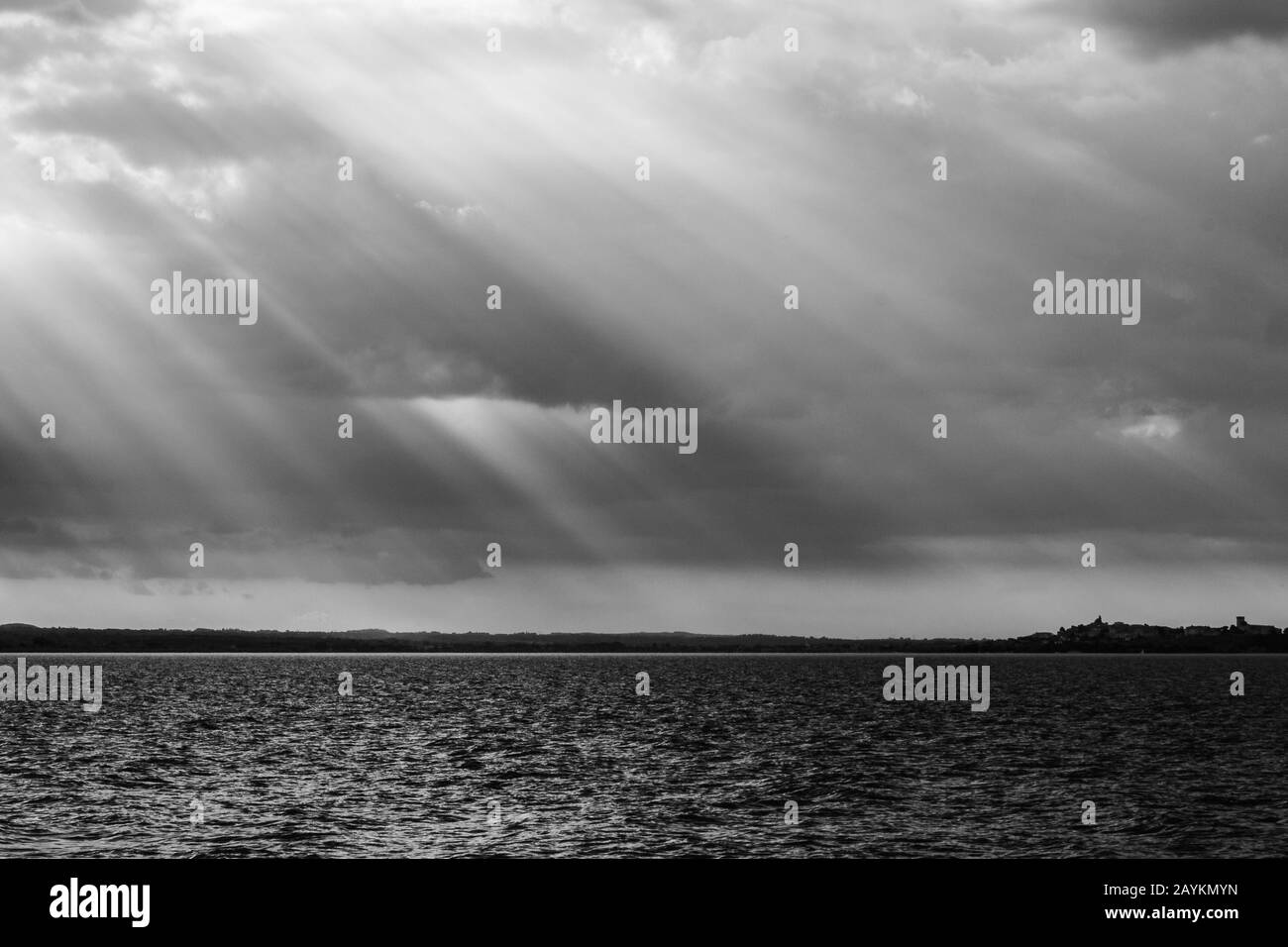 Sonnenstrahlen bei Sonnenuntergang, dunkle Wolken im Hintergrund, über dem Trasimeno-See (Umbrien, Italien) Stockfoto