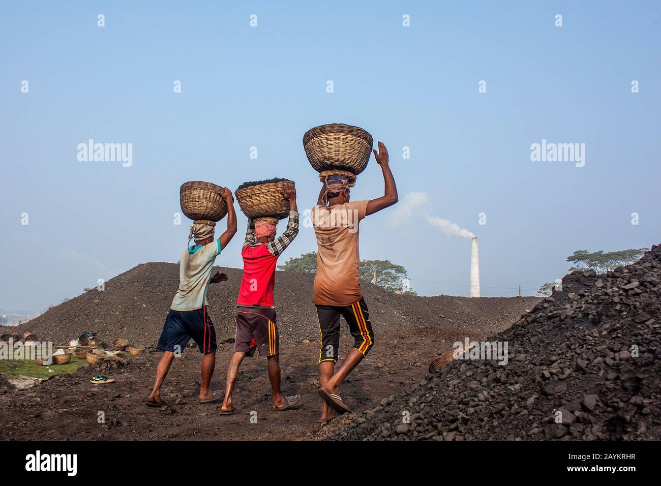 Der Arbeiter trägt einen Korb Kohle, der im Brennofen eines Maurers verwendet werden soll.Khulna, Bangladesch. Stockfoto