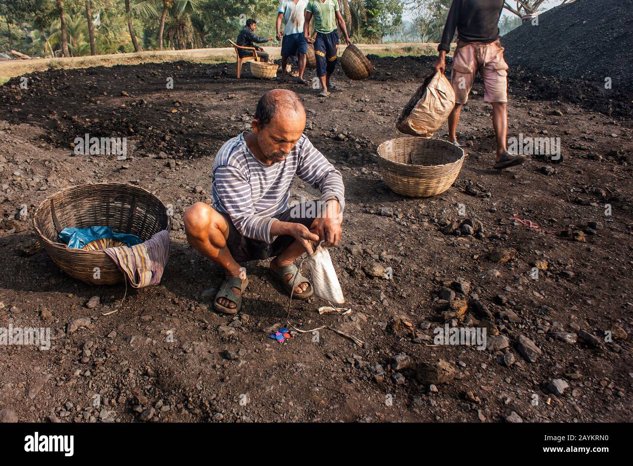 Der Arbeiter trägt einen Korb Kohle, der im Brennofen eines Maurers verwendet werden soll.Khulna, Bangladesch. Stockfoto