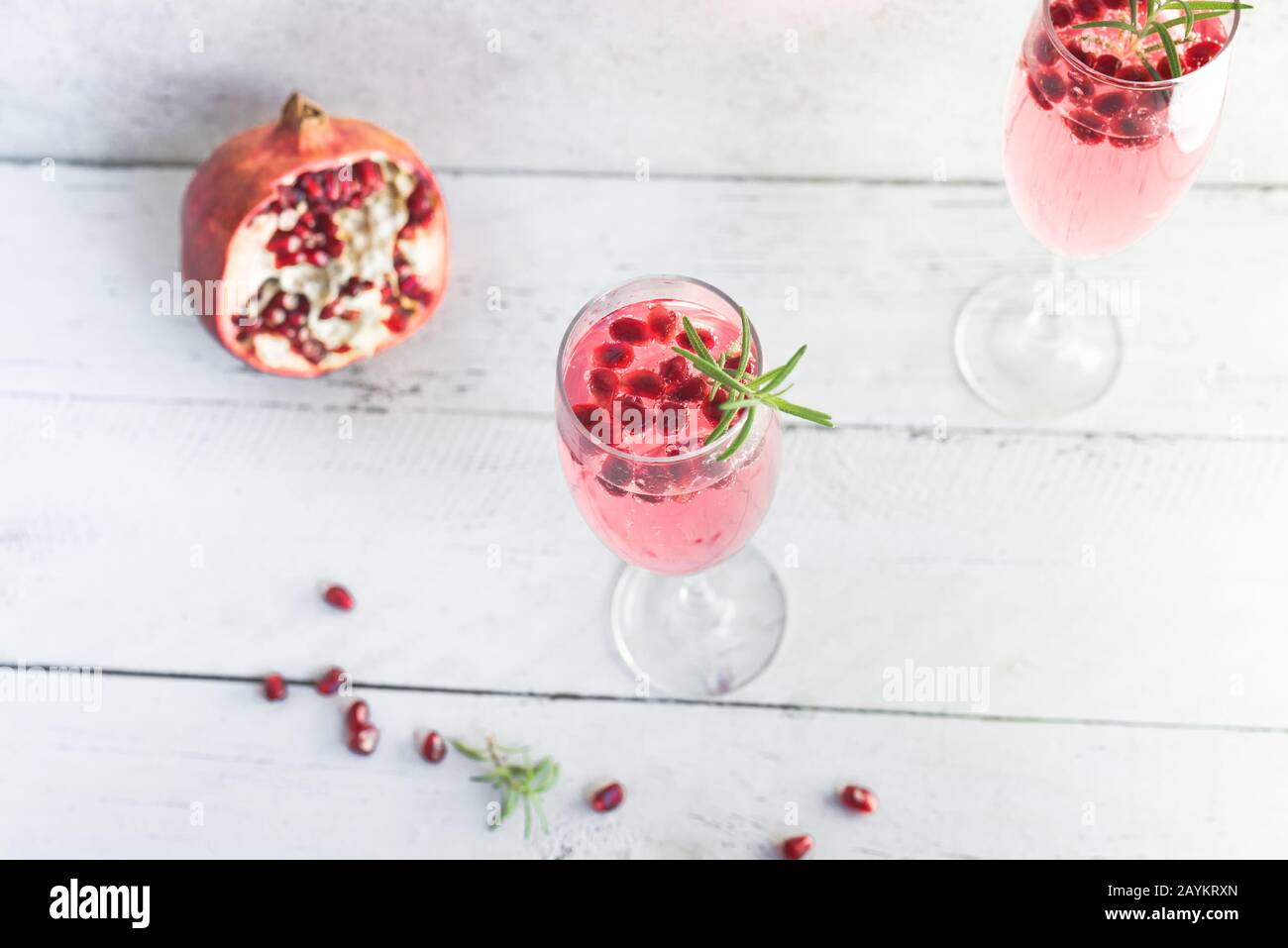 Mimosa-Cocktail mit Rosen-Champagner, Granatapfel und Rosmarin in Flötenbrille, Kopierraum. Mocktail, Mimosa Sekt Rosa Getränk. Stockfoto