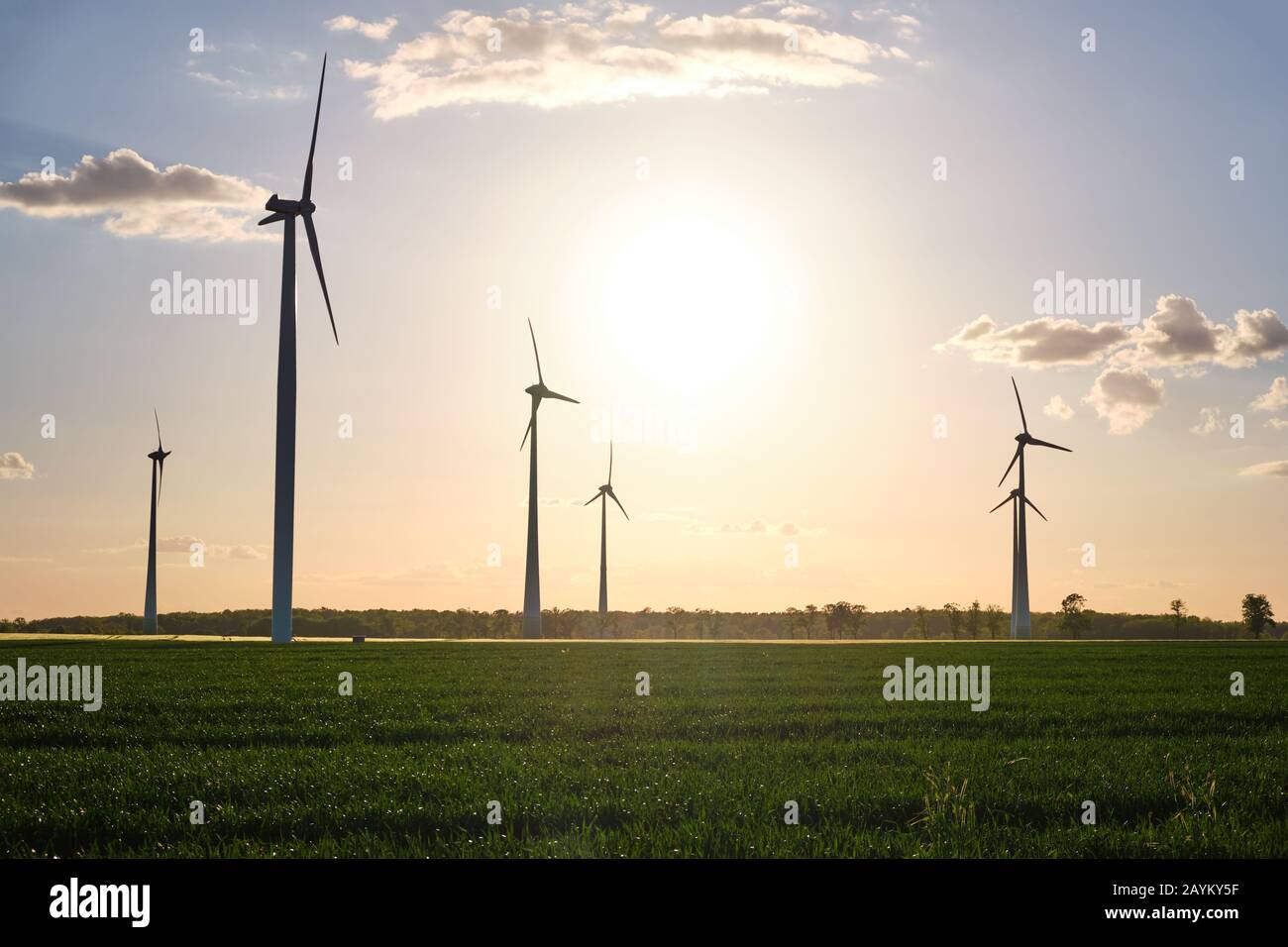 Landschaft mit modernen Windkraftanlagen kurz vor Sonnenuntergang in Deutschland zu sehen Stockfoto