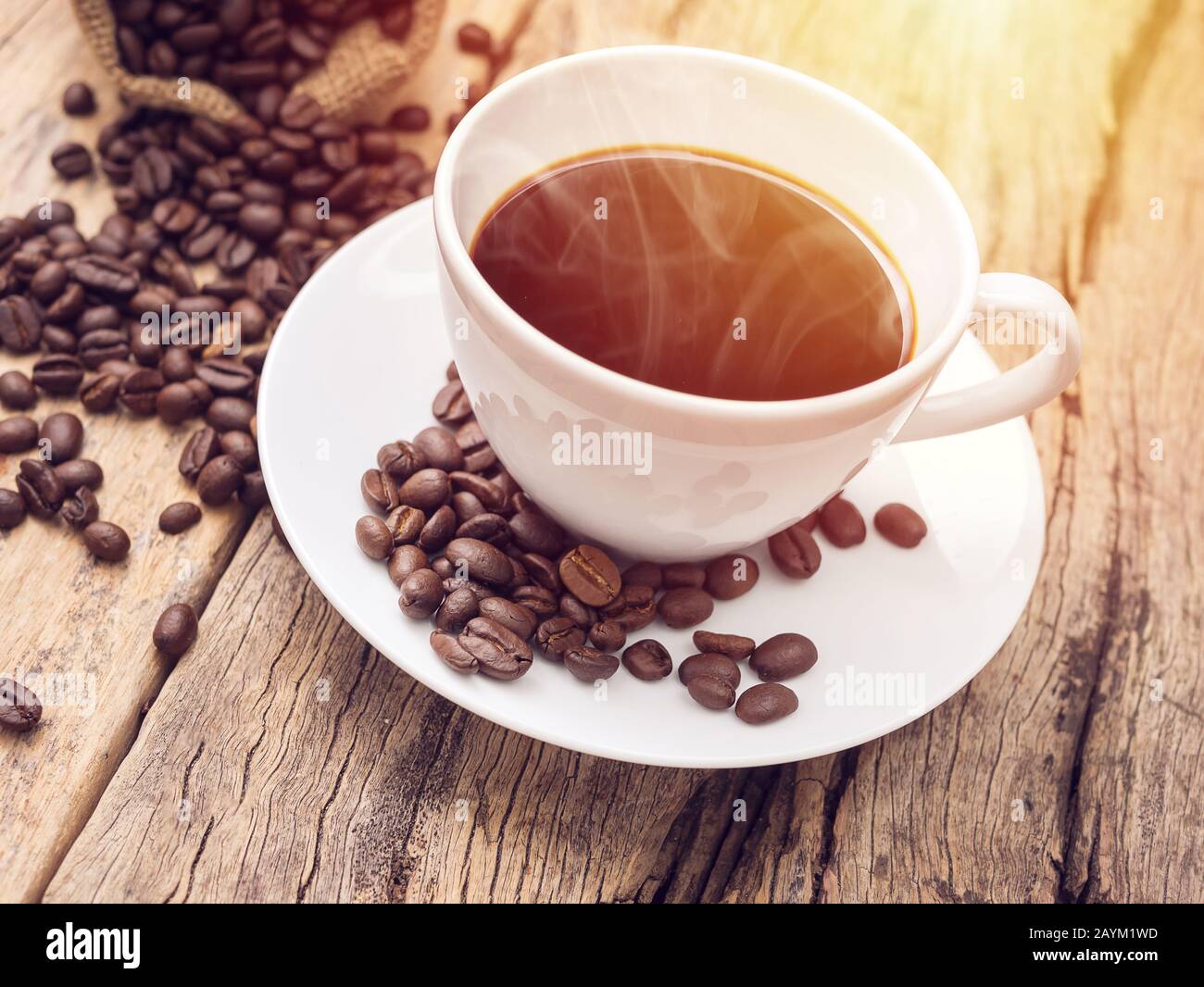 Heiße Kaffeetasse mit Kaffeebohne auf Holztisch. Kaffeeshintergrund für Café oder Café-Bar Stockfoto