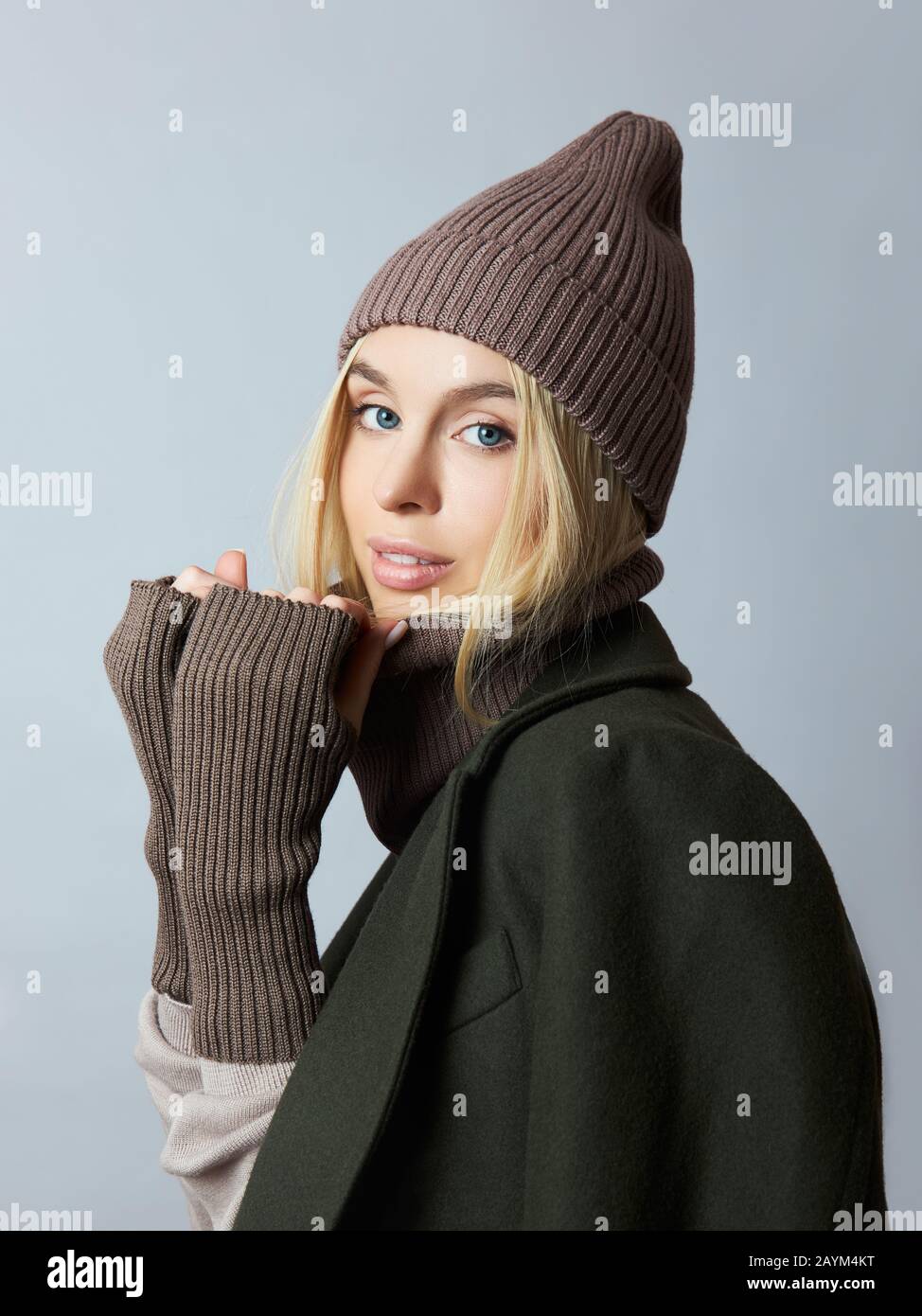 Frau im Mantel, Federkleidung, ein Snood-Schal, ein Hut und Handschuhe. Das  Mädchen ist blond mit blauen Augen. Warme Kleidung für kaltes  Frühlingswetter Stockfotografie - Alamy