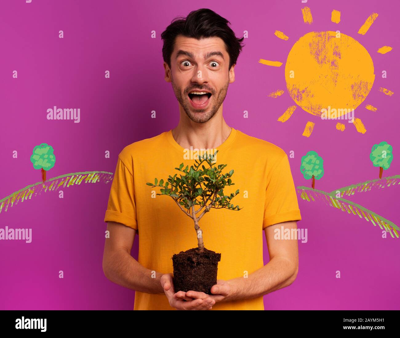 Der glückliche Junge hält einen kleinen Baum bereit, der über eine Lichtfarbe gepflanzt werden kann. Konzept der Aufforstung, Ökologie und Erhaltung Stockfoto