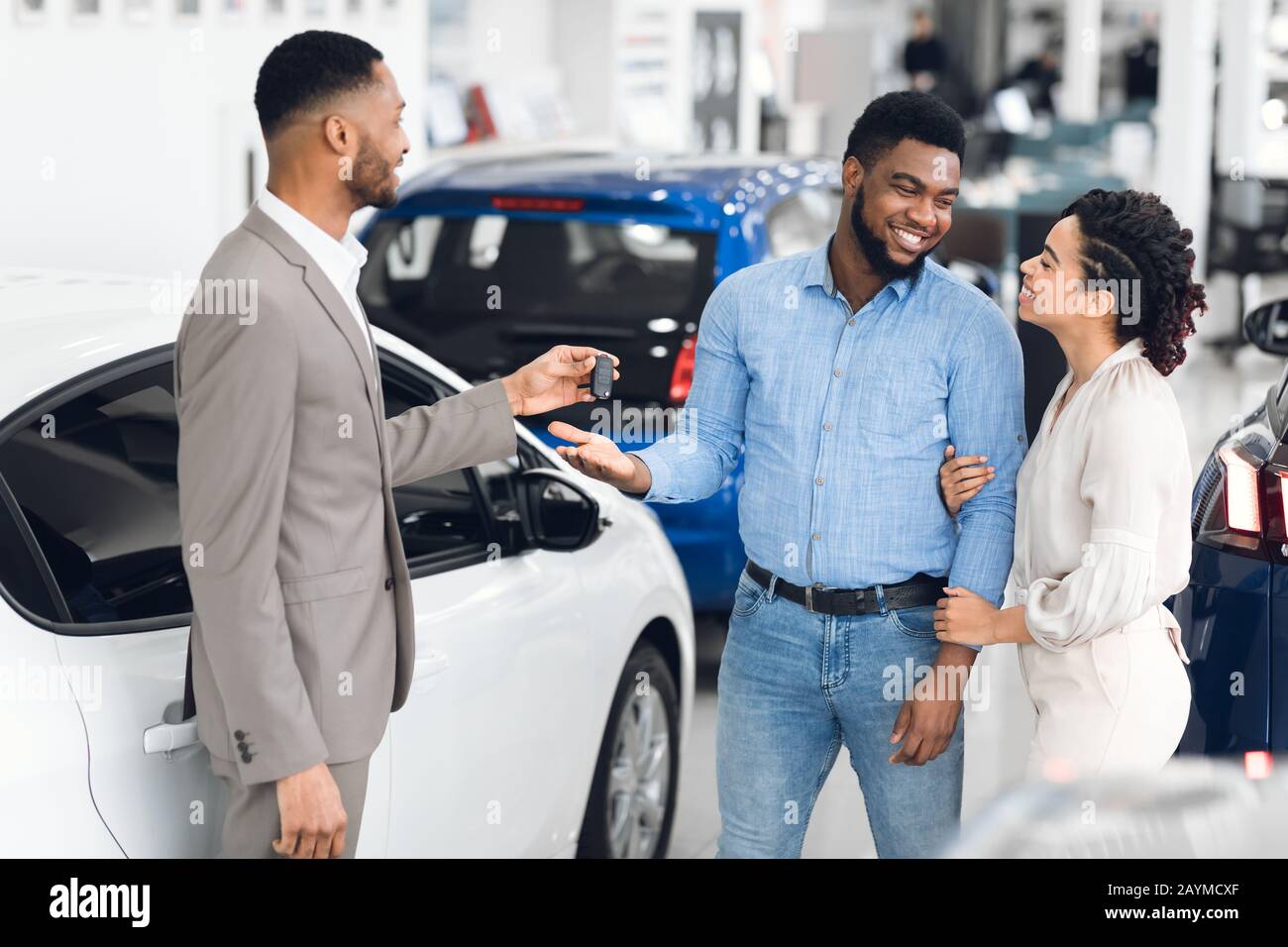 Familie Kauft Auto Taking Key Vom Autohändler Im Geschäft Stockfoto